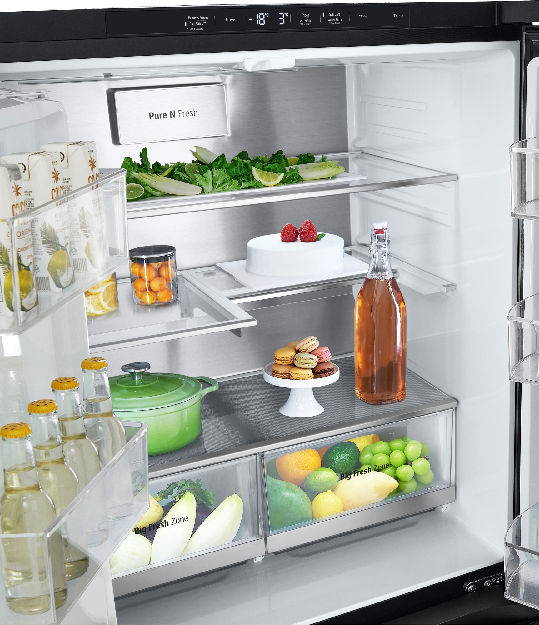 Wewnątrz lodówki, wypełnionej jedzeniem i napojami. Szklane półki, produkty, ciasta i butelki.