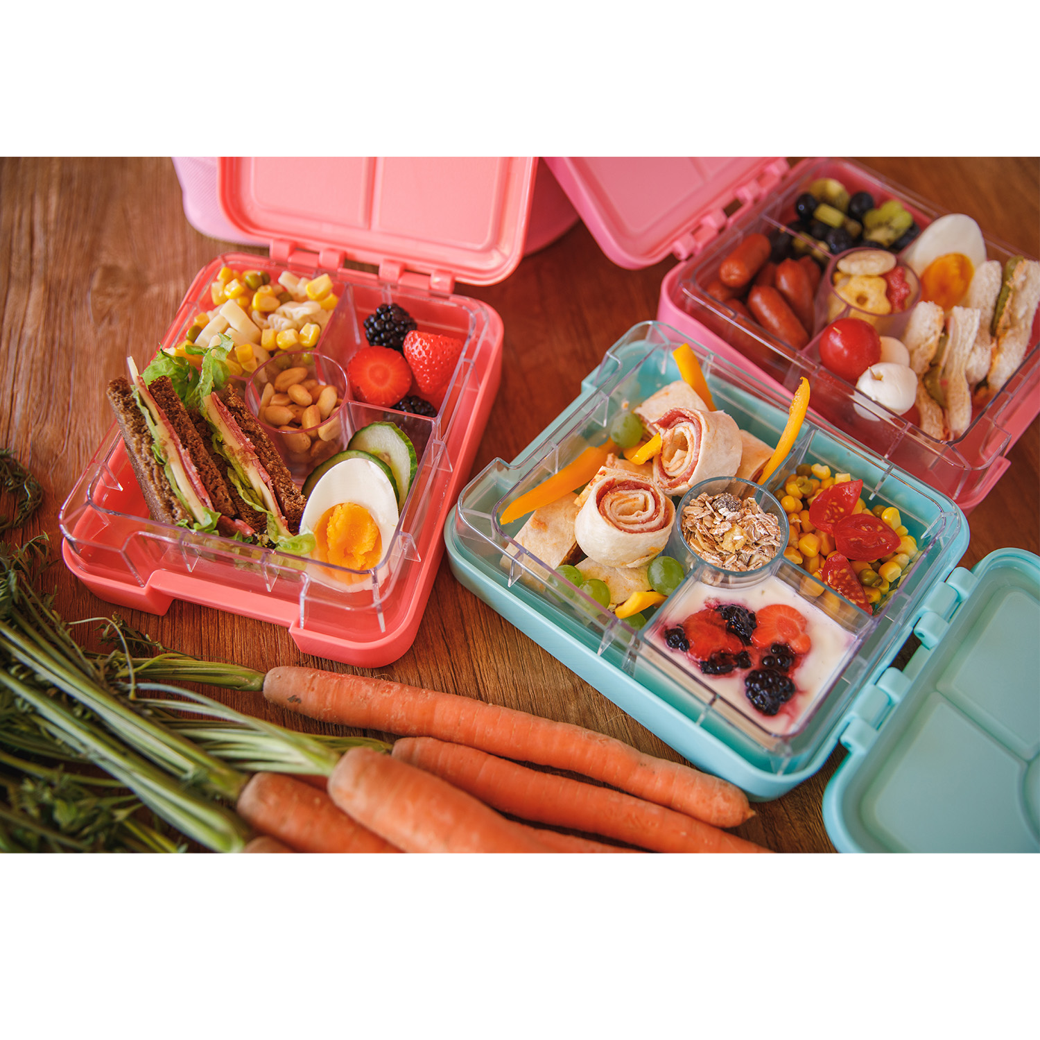Bunte Brotdosen mit Sandwiches, Obst und Gemüse.