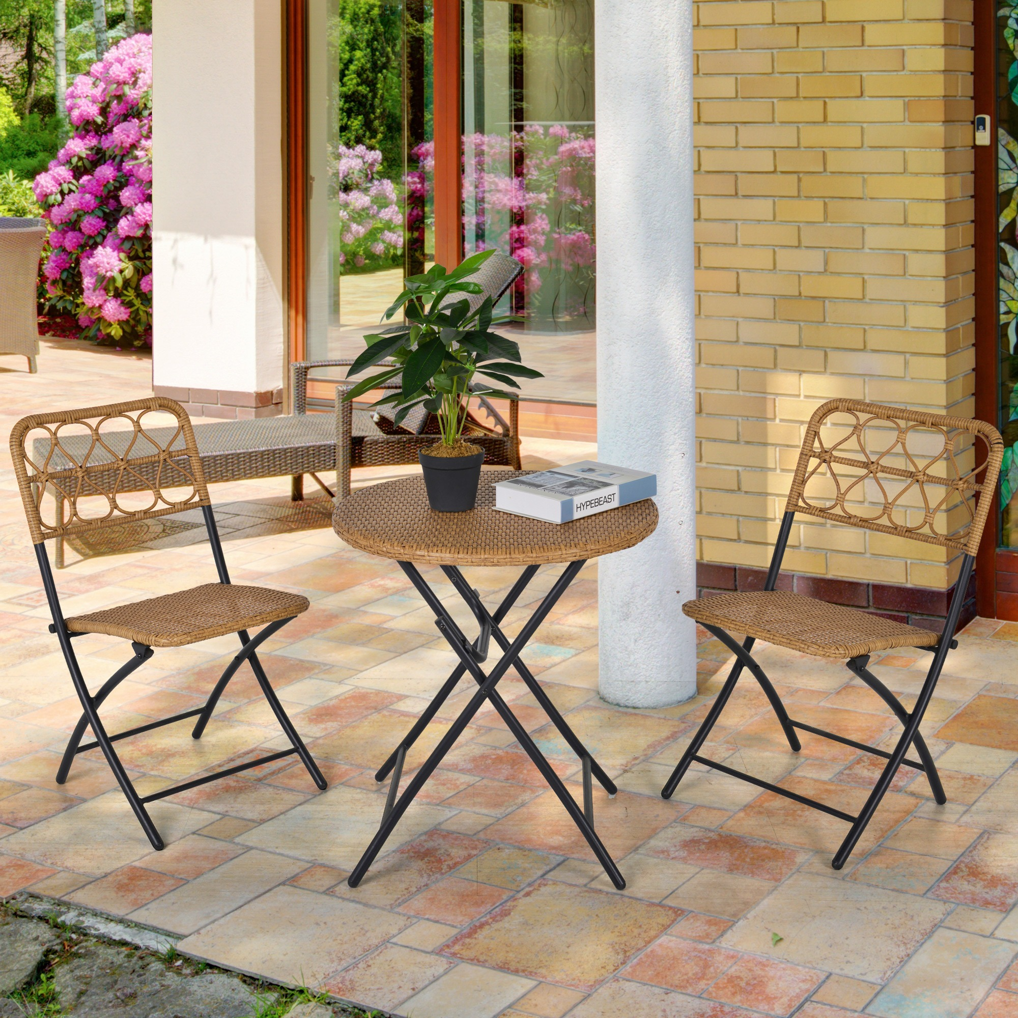 Ein Terrassenset mit einem runden Tisch und zwei Stühlen. Der Tisch hat eine gewebte Oberfläche.
