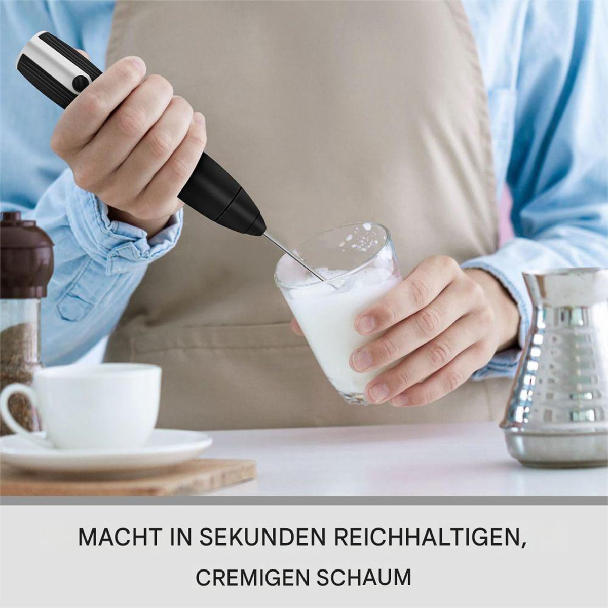 Eine Person verwendet einen Milchaufschäumer, um Schaum in einem Glas zu erzeugen.