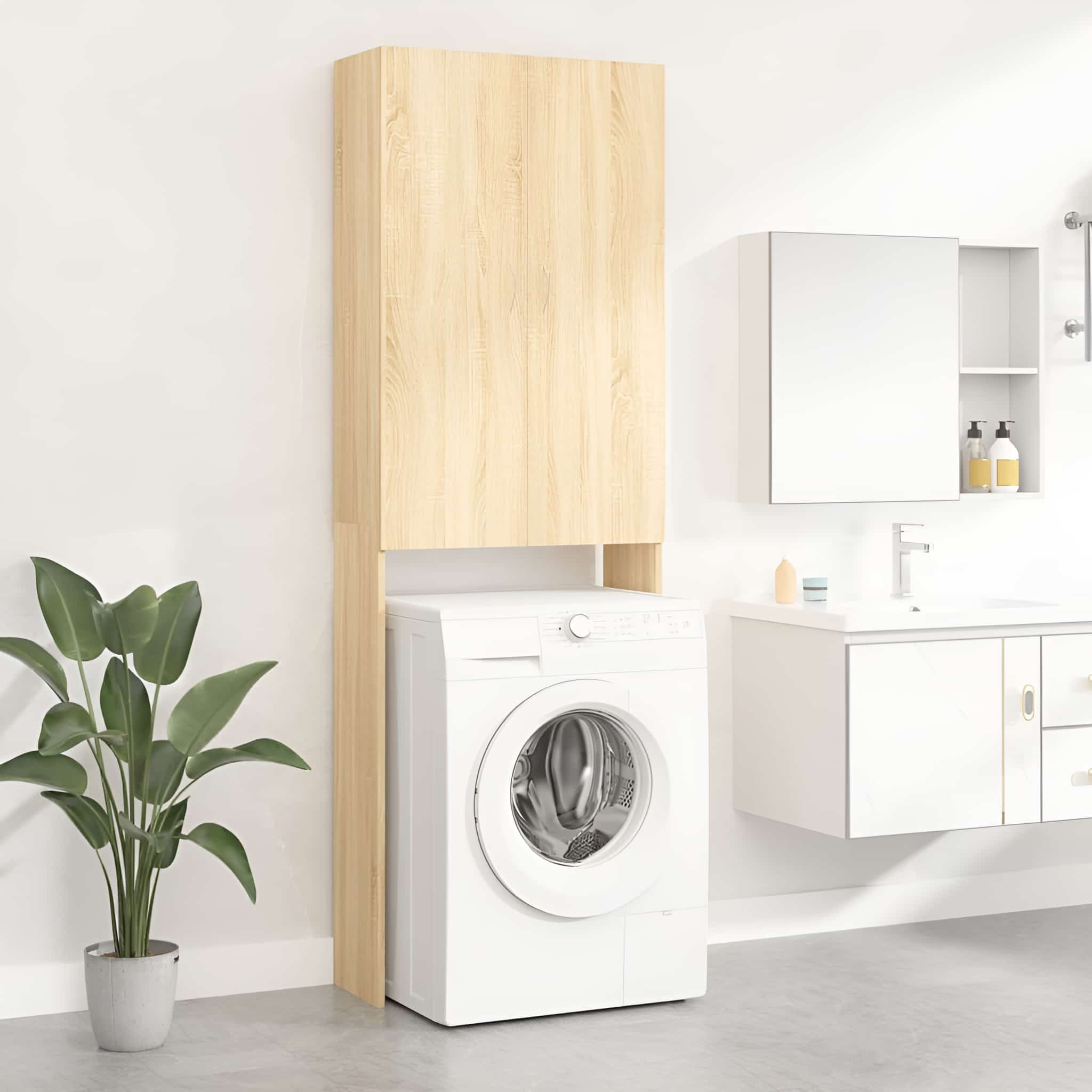 Eine Waschmaschine mit einem Holzschrank darüber, vor einer weißen Wand. Links ist eine Pflanze.