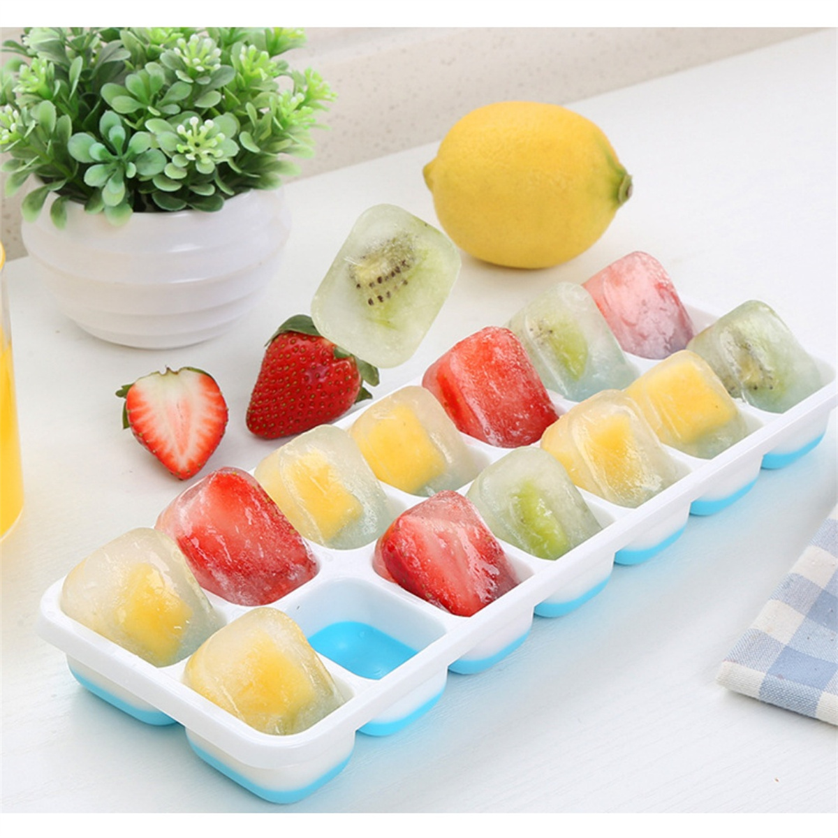 Ein Tablett mit Eiswürfeln mit verschiedenen Früchten wie Erdbeeren, Kiwi und Mango.