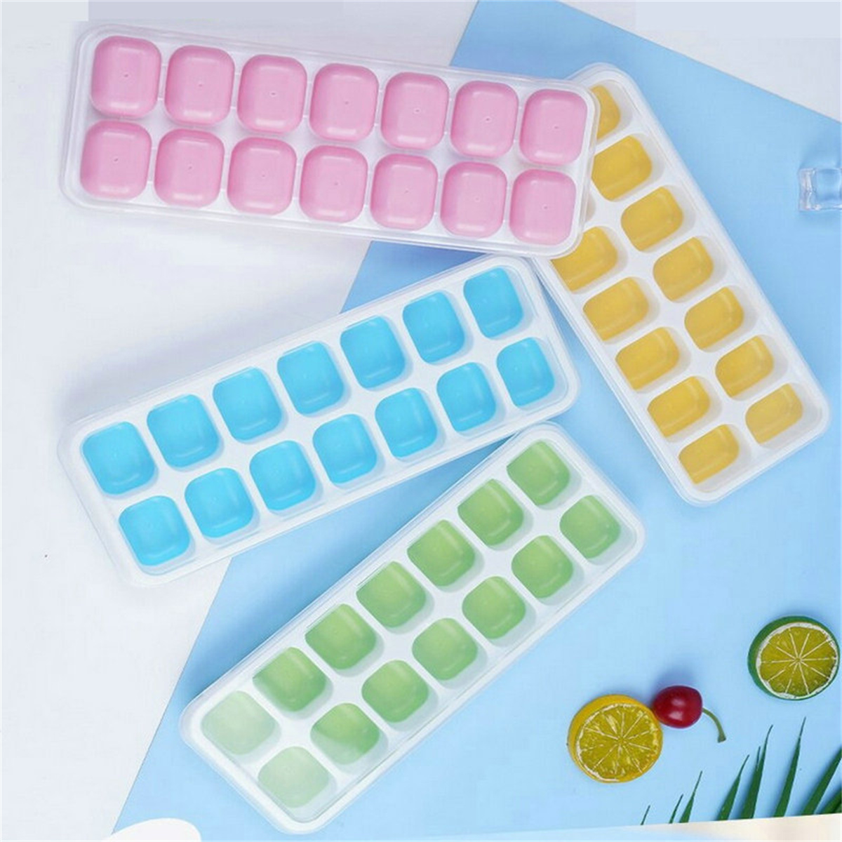 Eiswürfelformen mit rosa, blauen, grünen und gelben Würfeln auf einer blau-weißen Oberfläche.
