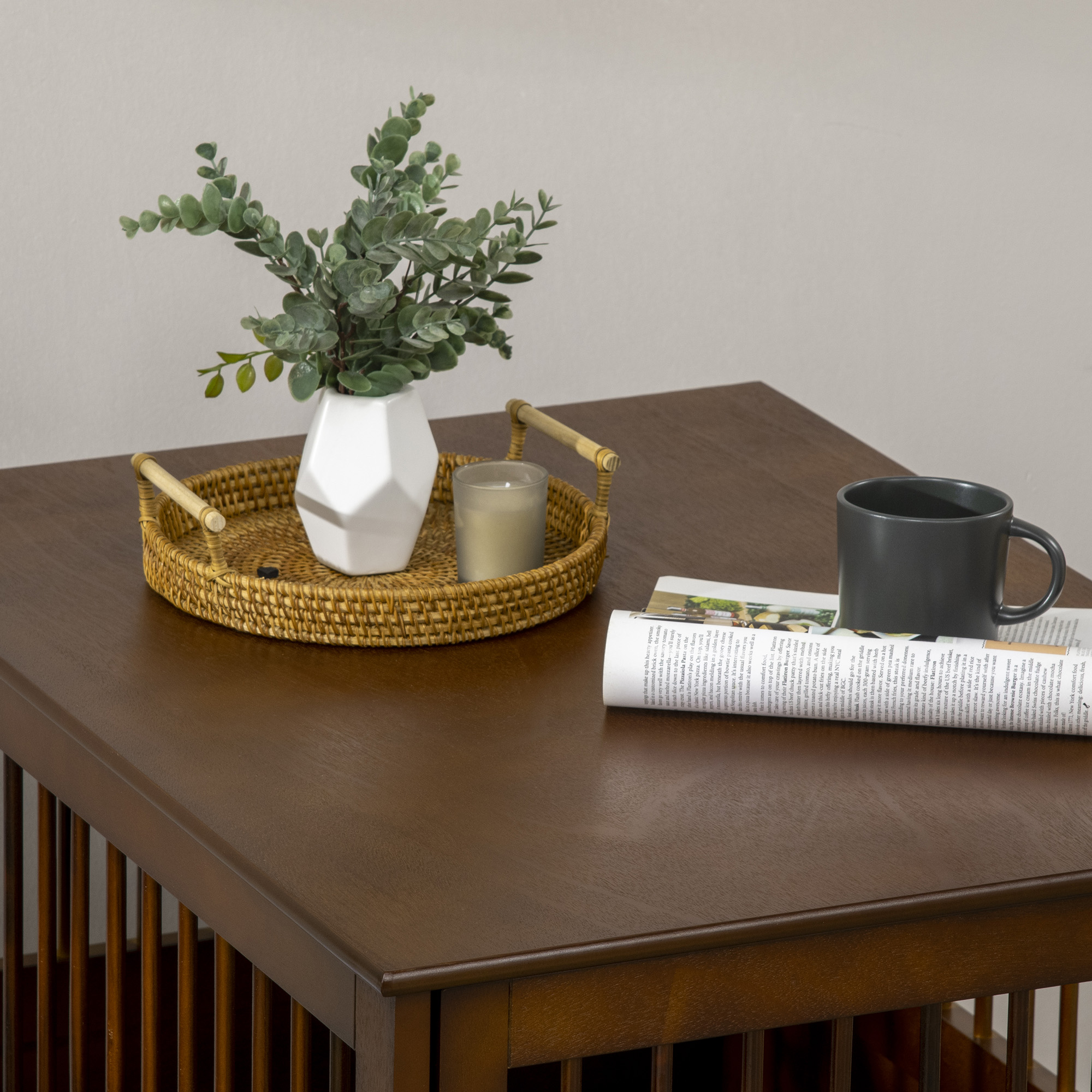 Tisch mit Vase, Blumen, Tablett mit Kerze und einer Zeitschrift und einer Tasse.
