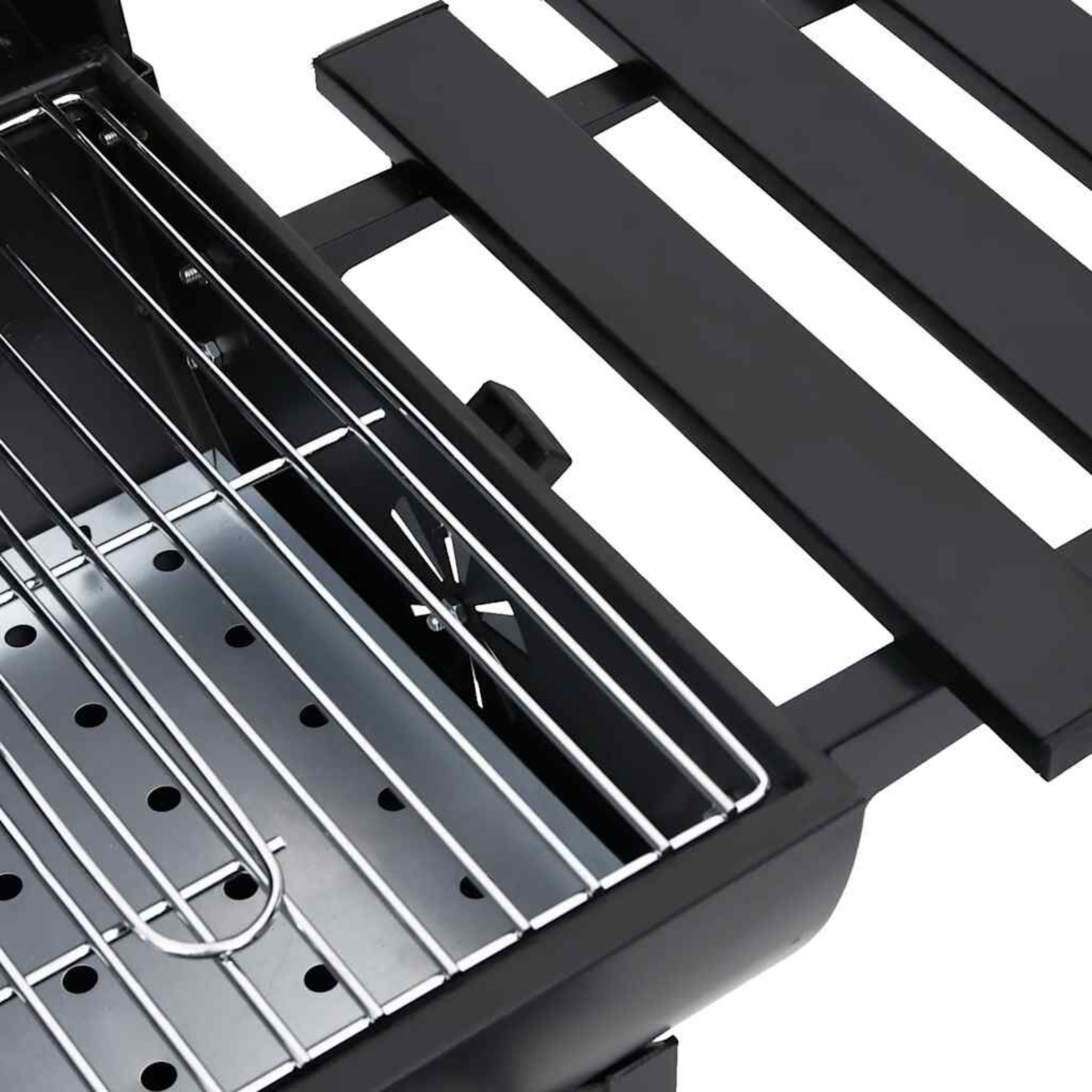 Nahaufnahme des Inneren eines Grills mit Grillrost und Holzkohlebehälter.