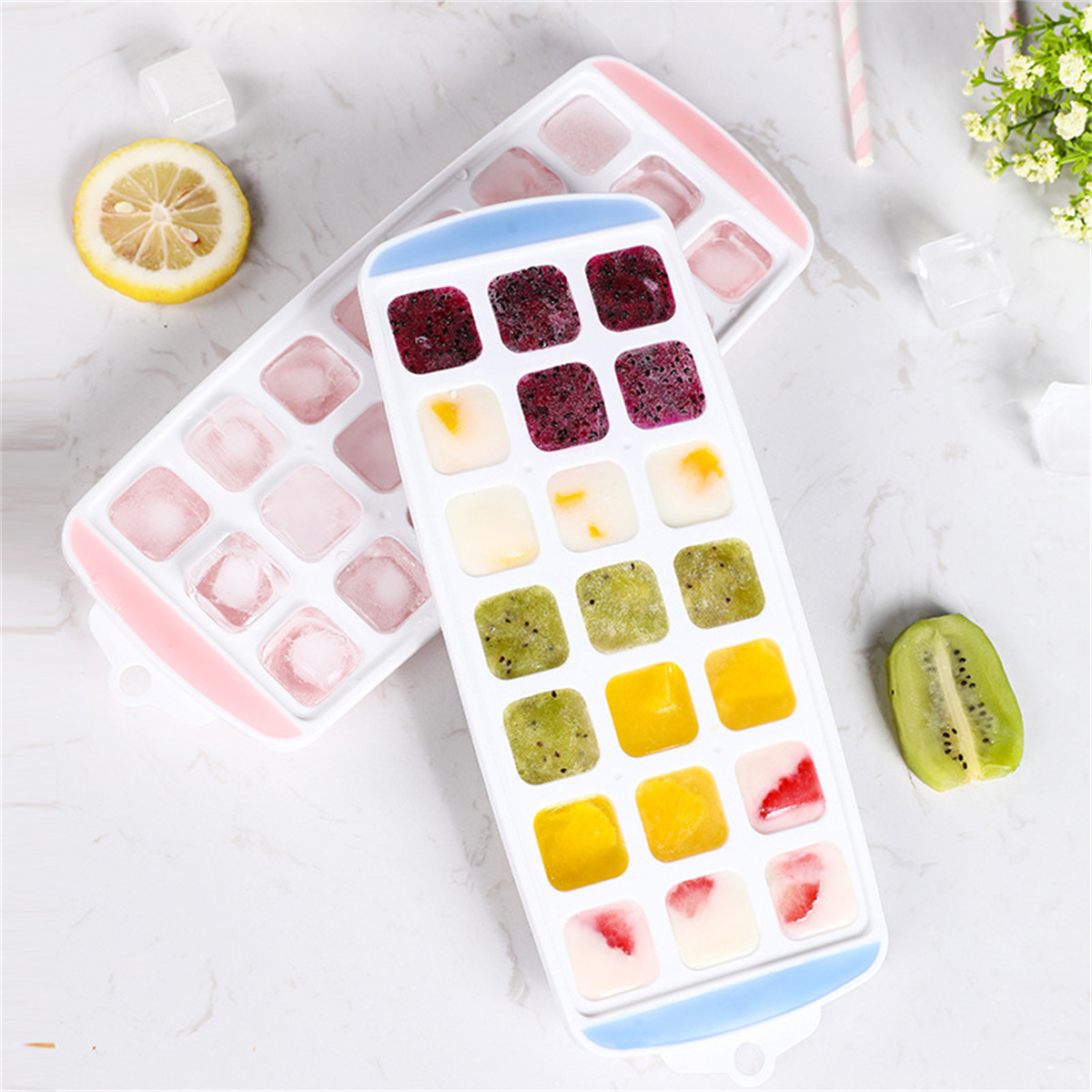 Eiswürfelschalen mit bunten Früchten und Eis. Zitrone und Kiwi sind ebenfalls vorhanden.
