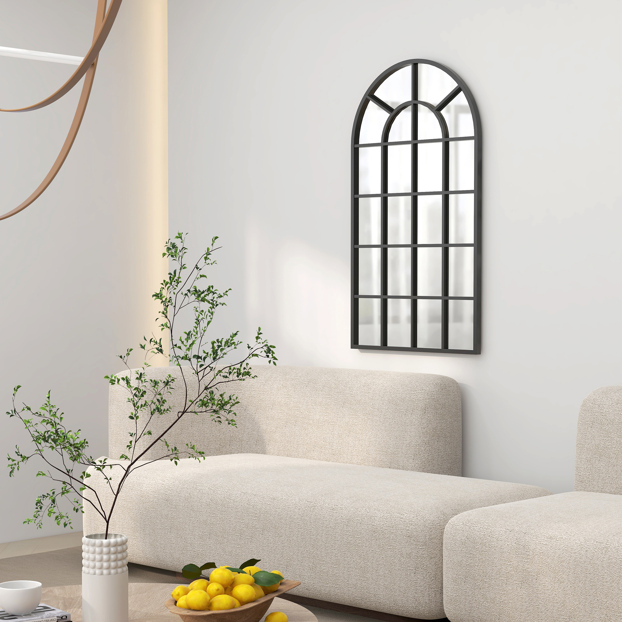 Schwarzer bogenförmiger Spiegel an weißer Wand. Der Spiegel hat ein Gittermuster. Ein Sofa und eine Pflanze im Vordergrund.