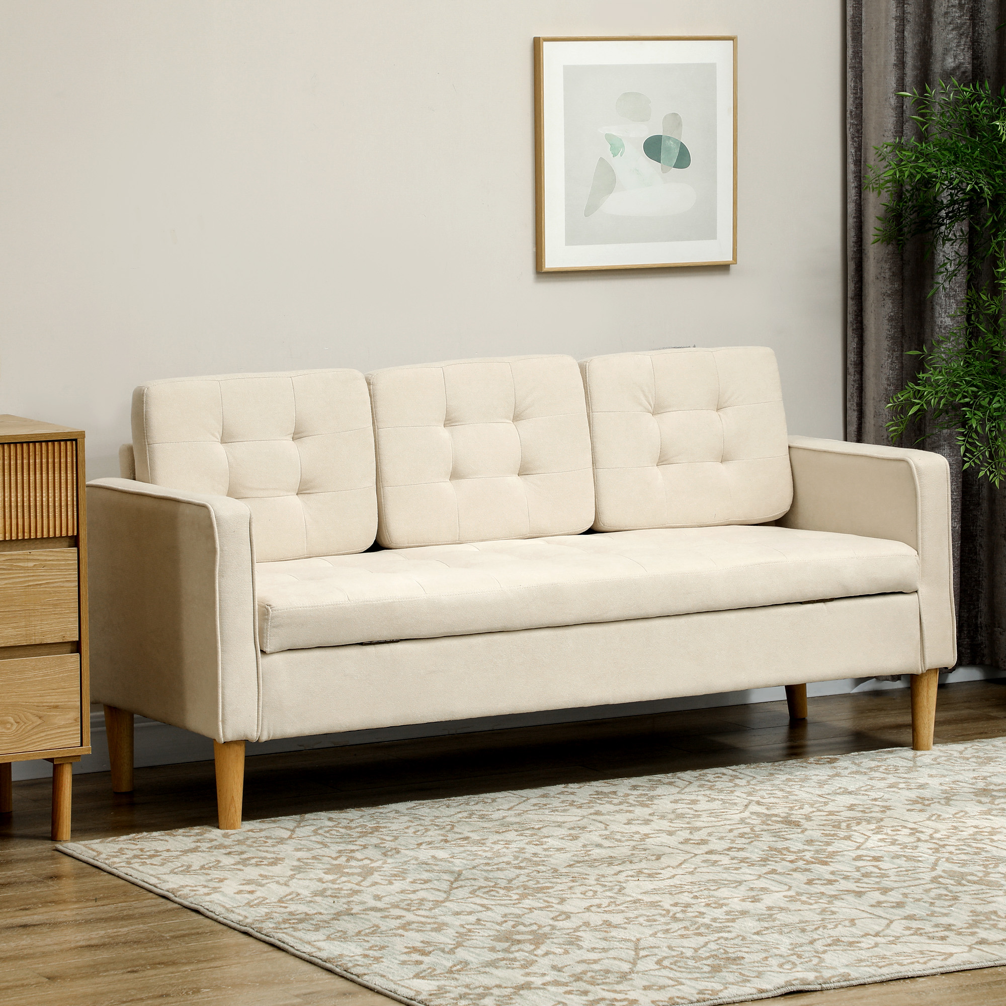 Cremefarbene Couch mit drei getufteten Kissen, Holzbeinen, in einem Raum mit Teppich und Bild.