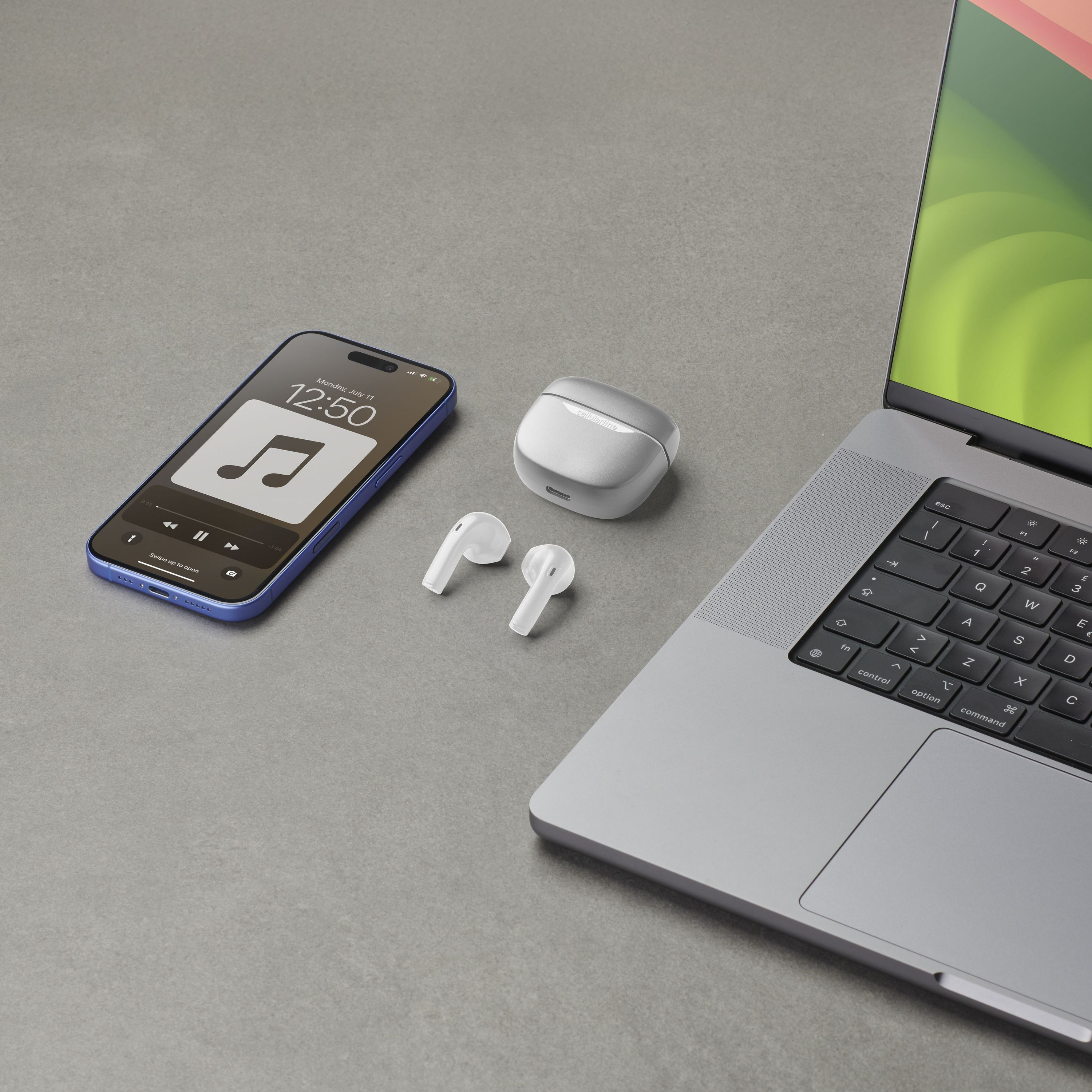 Telefon und Ohrhörer in der Nähe eines Laptops. Ohrhörer sind im Etui. Grauer Hintergrund.