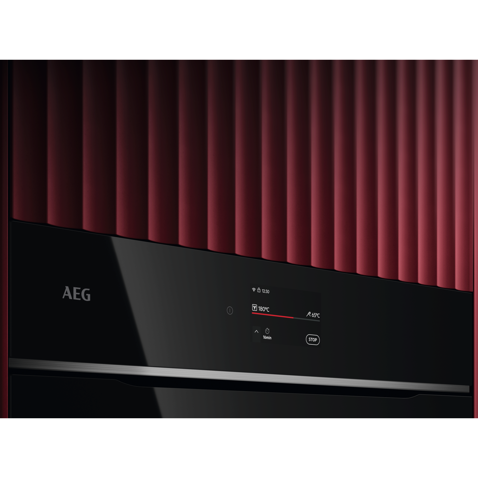 Forno AEG con sfondo rosso. Pannello nero con display.