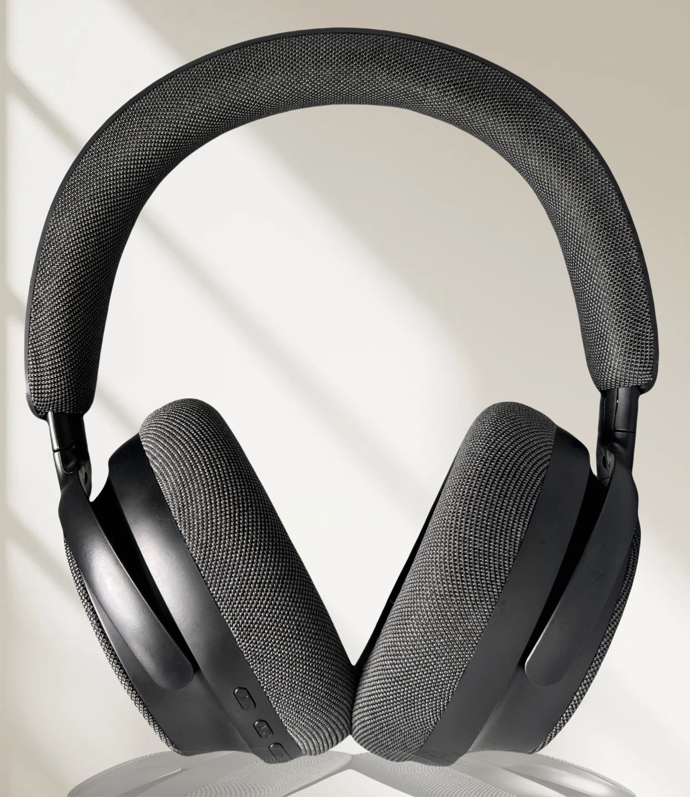 Auriculares negros sobre fondo blanco con sombras suaves, resaltando el diseño y la textura de malla.