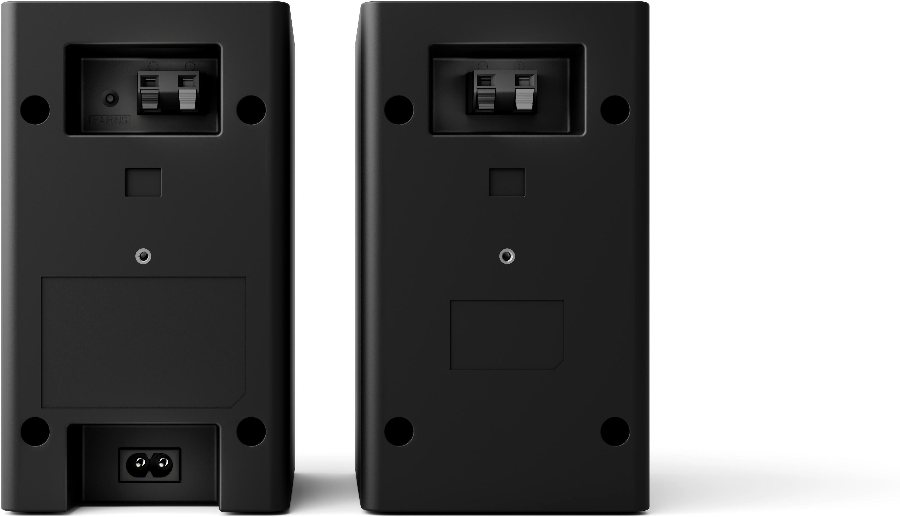 Dwa czarne głośniki pokazujące tyły, z widocznymi portami zasilania i połączeń.