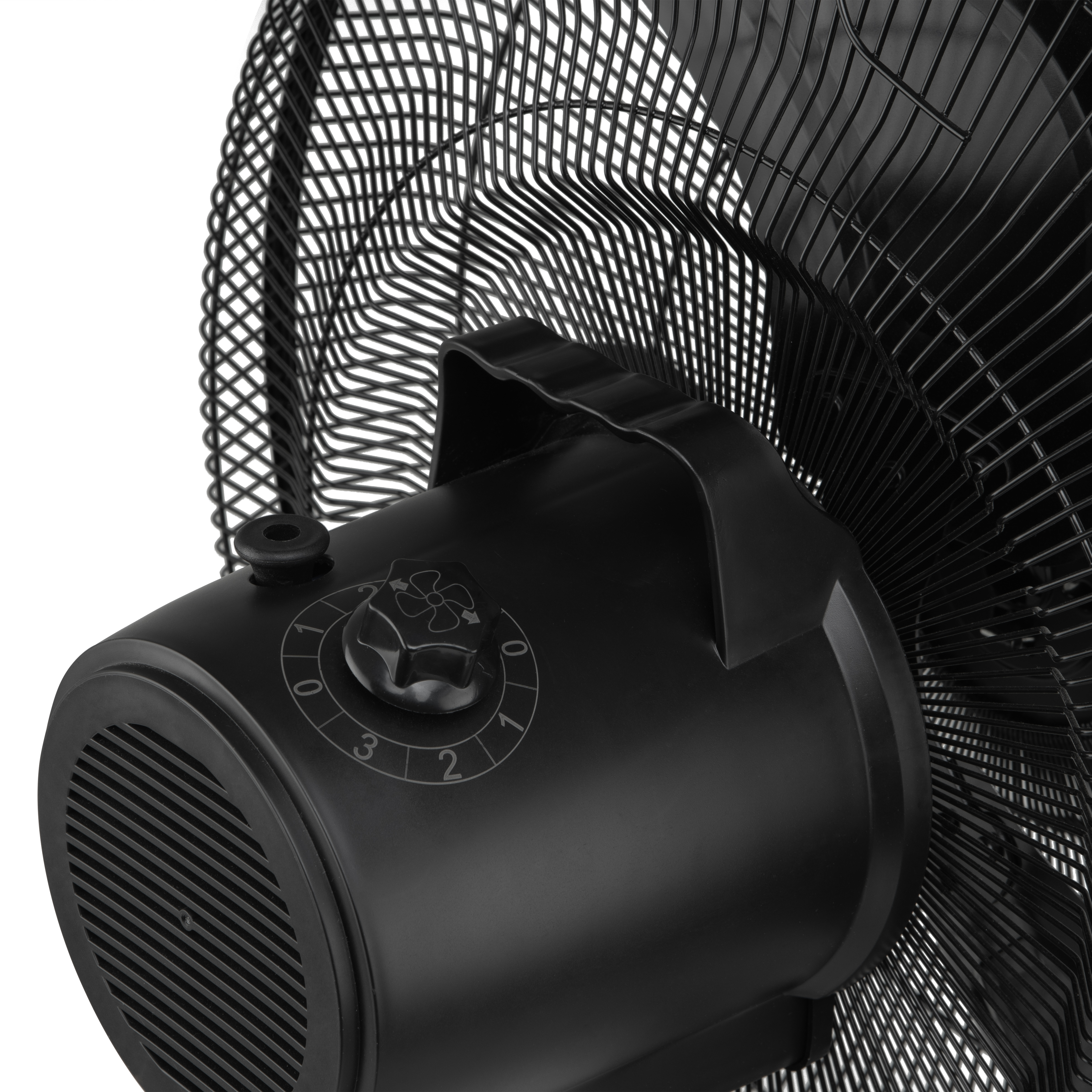 Primer plano de un ventilador negro con un dial de control y asa. Las aspas del ventilador son visibles.