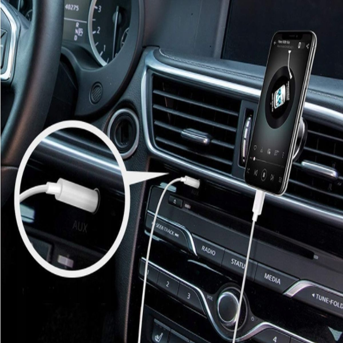 Telefon podłączony do portu AUX w samochodzie, odtwarzający muzykę, zamontowany na desce rozdzielczej, zbliżenie.