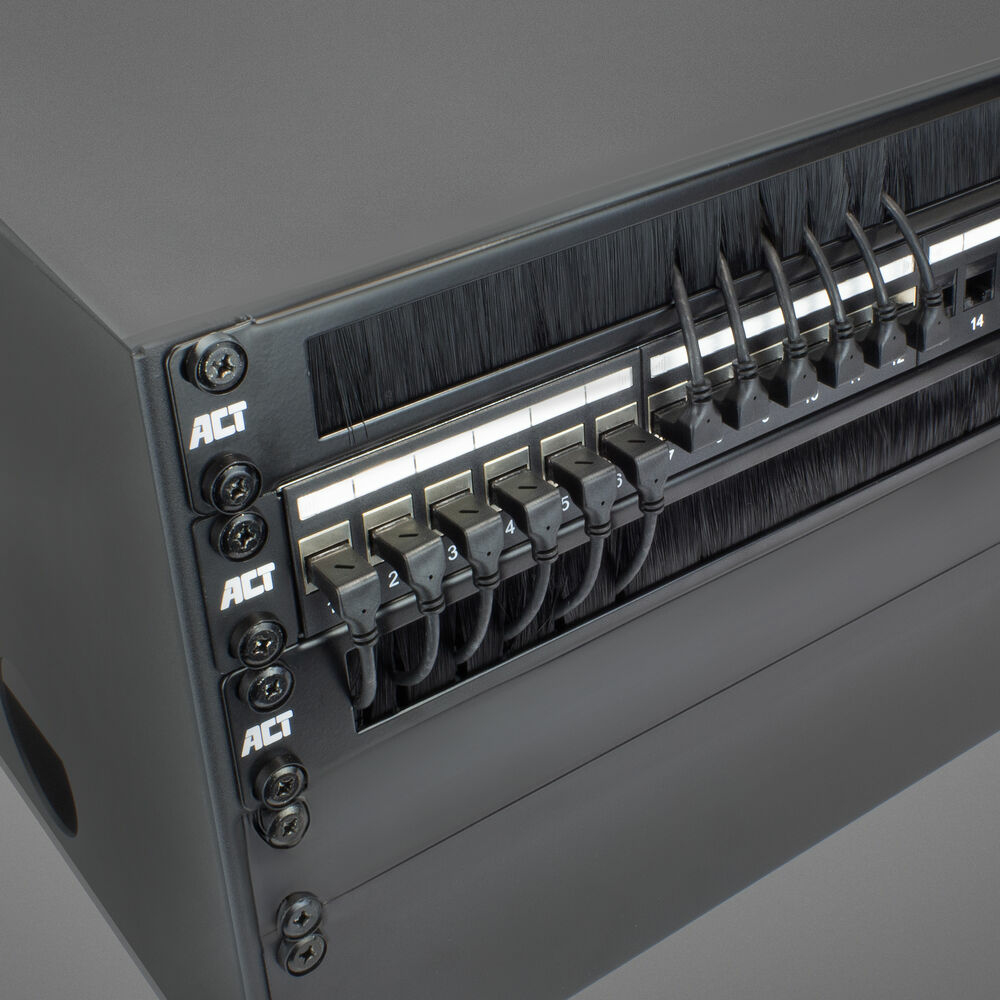 Czarny panel sieciowy z podłączonymi kablami. Widoczne etykiety i śruby ACT. Tło to szara powierzchnia.