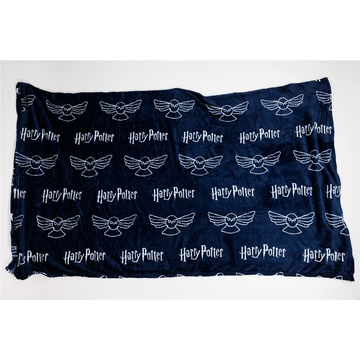 Dunkelblaue Harry Potter Decke mit weißen Eulenlogos und Text. Weißer Hintergrund. Gemütliche Ästhetik.