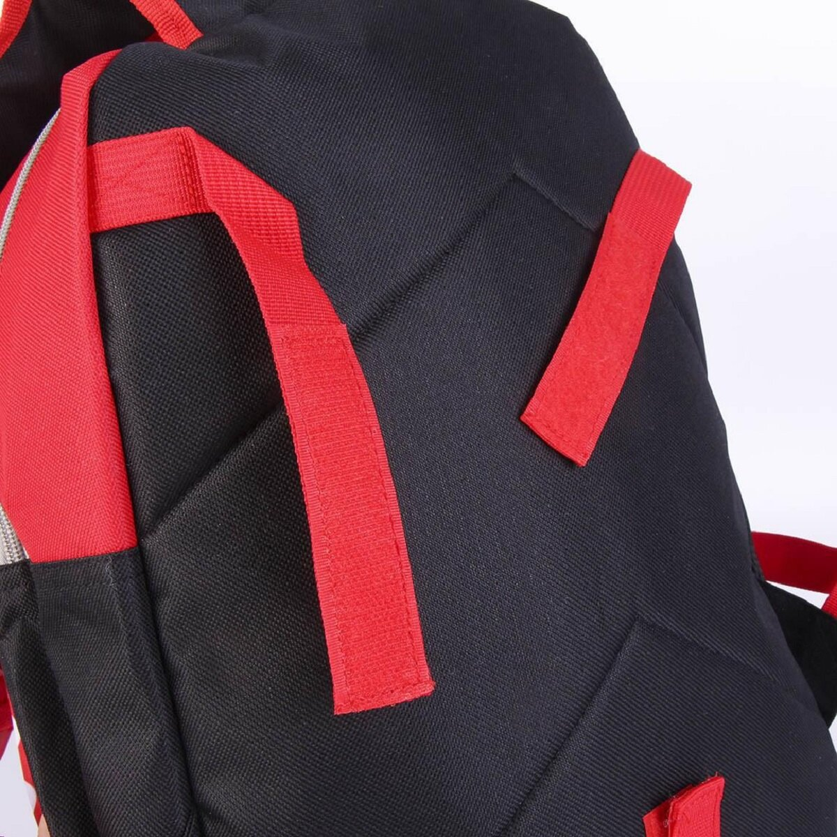 Schwarzer und roter Rucksack. Er hat rote Träger, einen grauen Reißverschluss und ein gepolstertes Design.