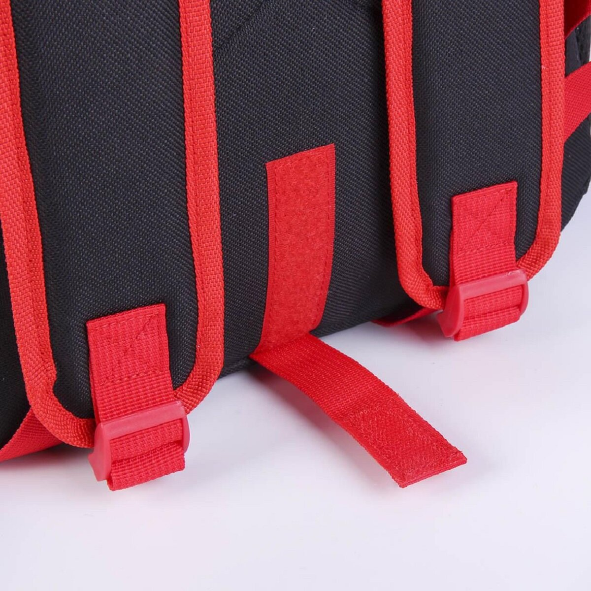 Schwarzer Rucksack mit roten Trägern und Schnallen. Nahaufnahme.