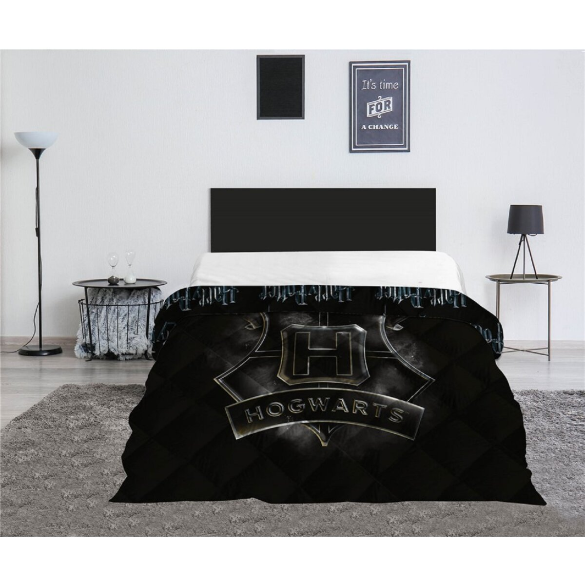 Hogwarts-Tagesdecke, schwarz mit Wappen. Bett mit weißen Laken, schwarzes Kopfteil. Grauer Teppich, weiße Wand.