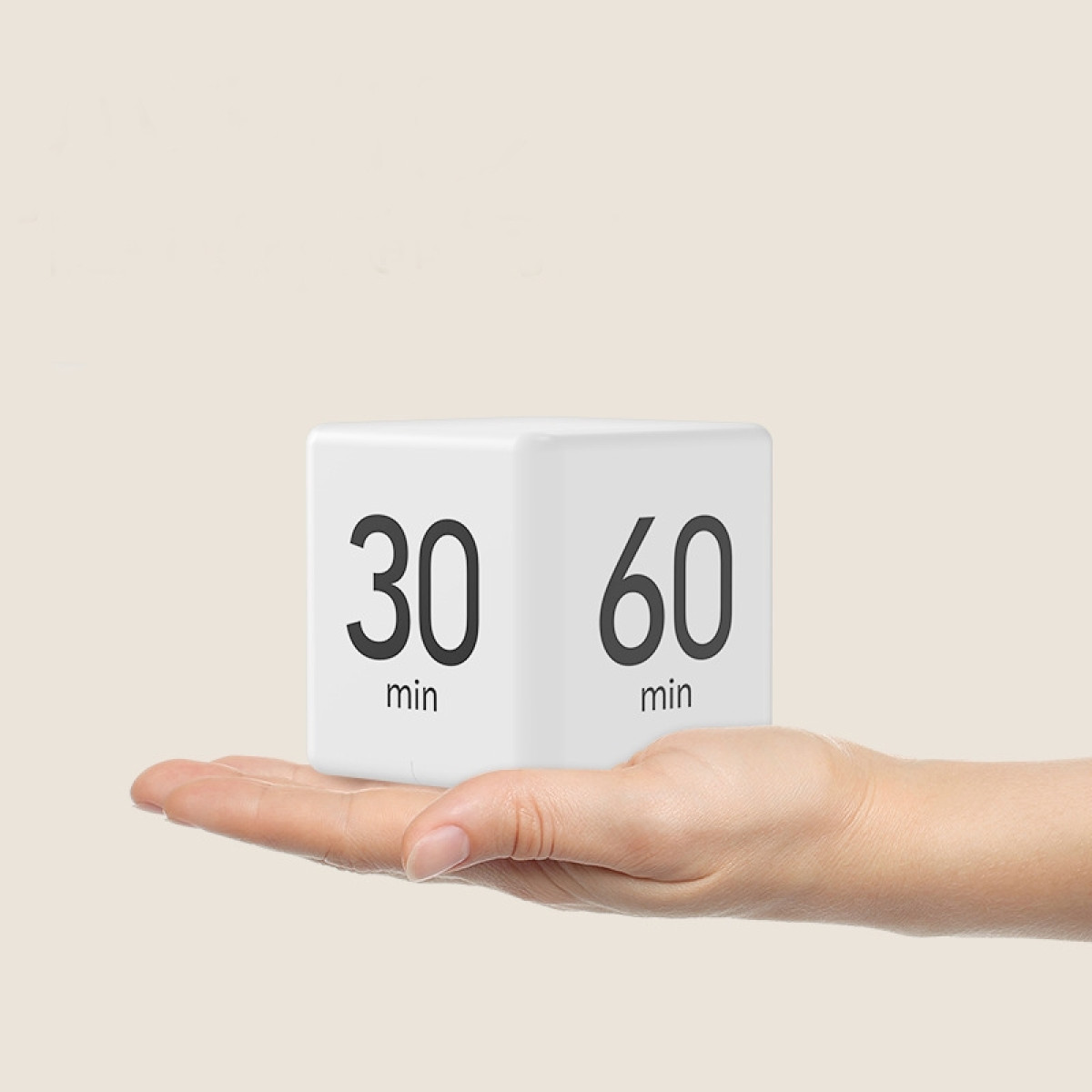 Ein weißer Würfel mit den Zahlen 30 und 60. Wird von einer Hand gehalten, zum Timen.