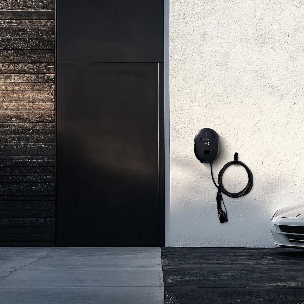 Electric car charger on wall. Black charger with cable and car visible.