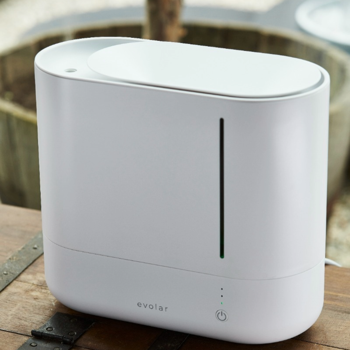 Umidificatore bianco su un tavolo di legno. Lo sfondo è sfocato.