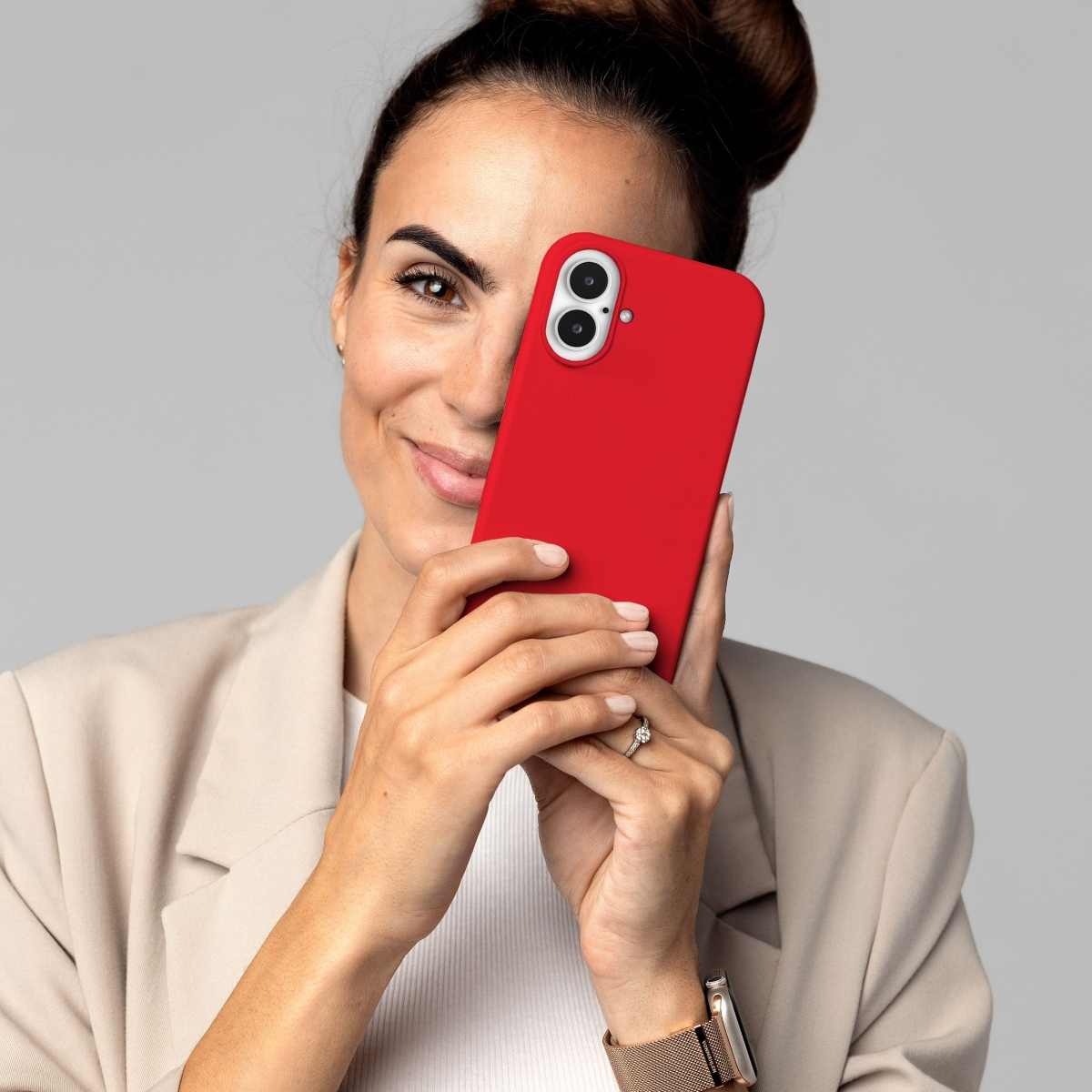 Frau hält eine rote Handyhülle vor ihr Gesicht.