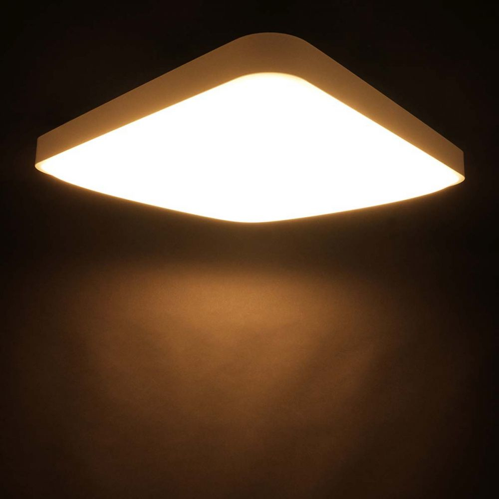 Un plafonnier carré blanc sur fond sombre.