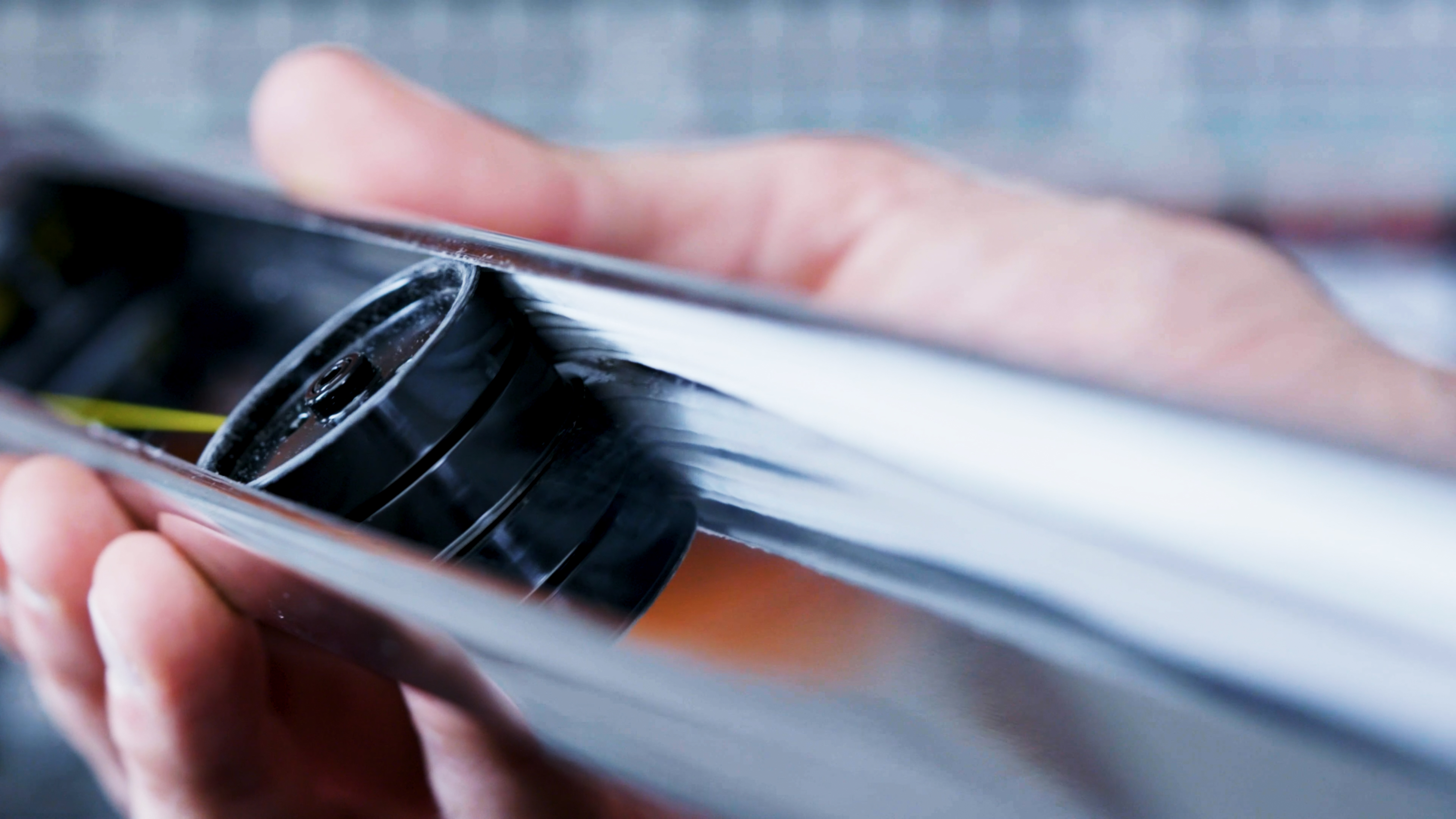 Primo piano di una mano che tiene un oggetto cilindrico. All'interno dell'oggetto, una parte nera è parzialmente visibile.