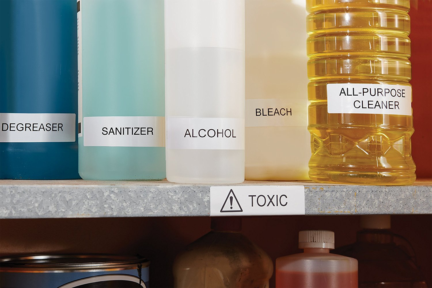 Scaffale con bottiglie di prodotti per la pulizia. Etichette: Sgrassatore, Disinfettante, Alcol, Candeggina e Detergente.