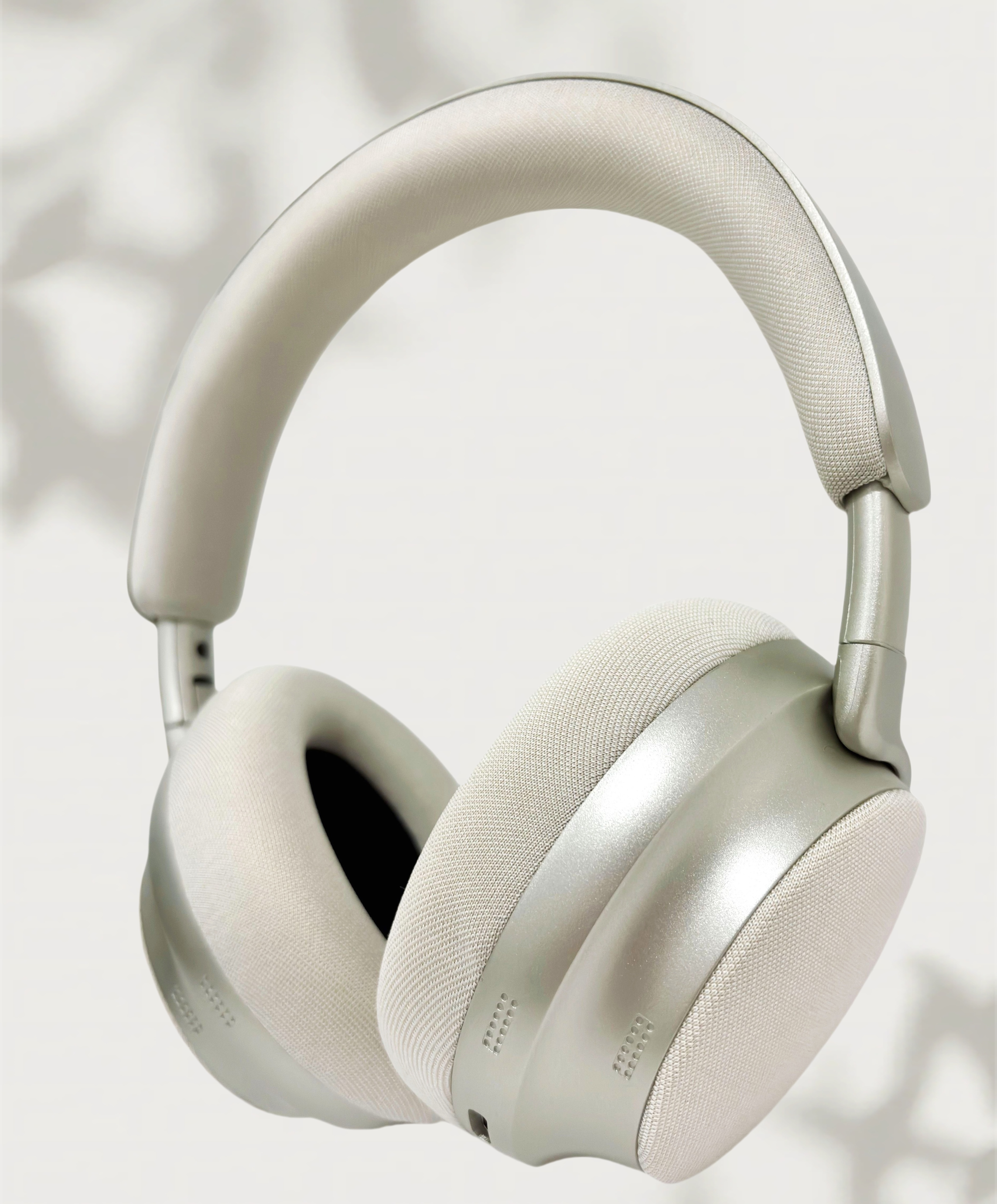 Auriculares blancos y plateados. Los auriculares están sobre un fondo blanco, con sombra. El diseño es moderno.