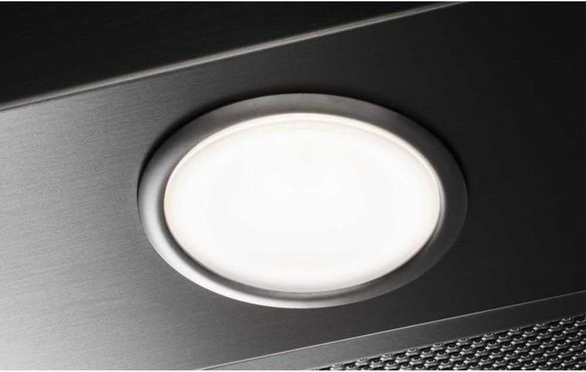 Zbliżenie jasnego, białego światła wewnątrz metalowego urządzenia.