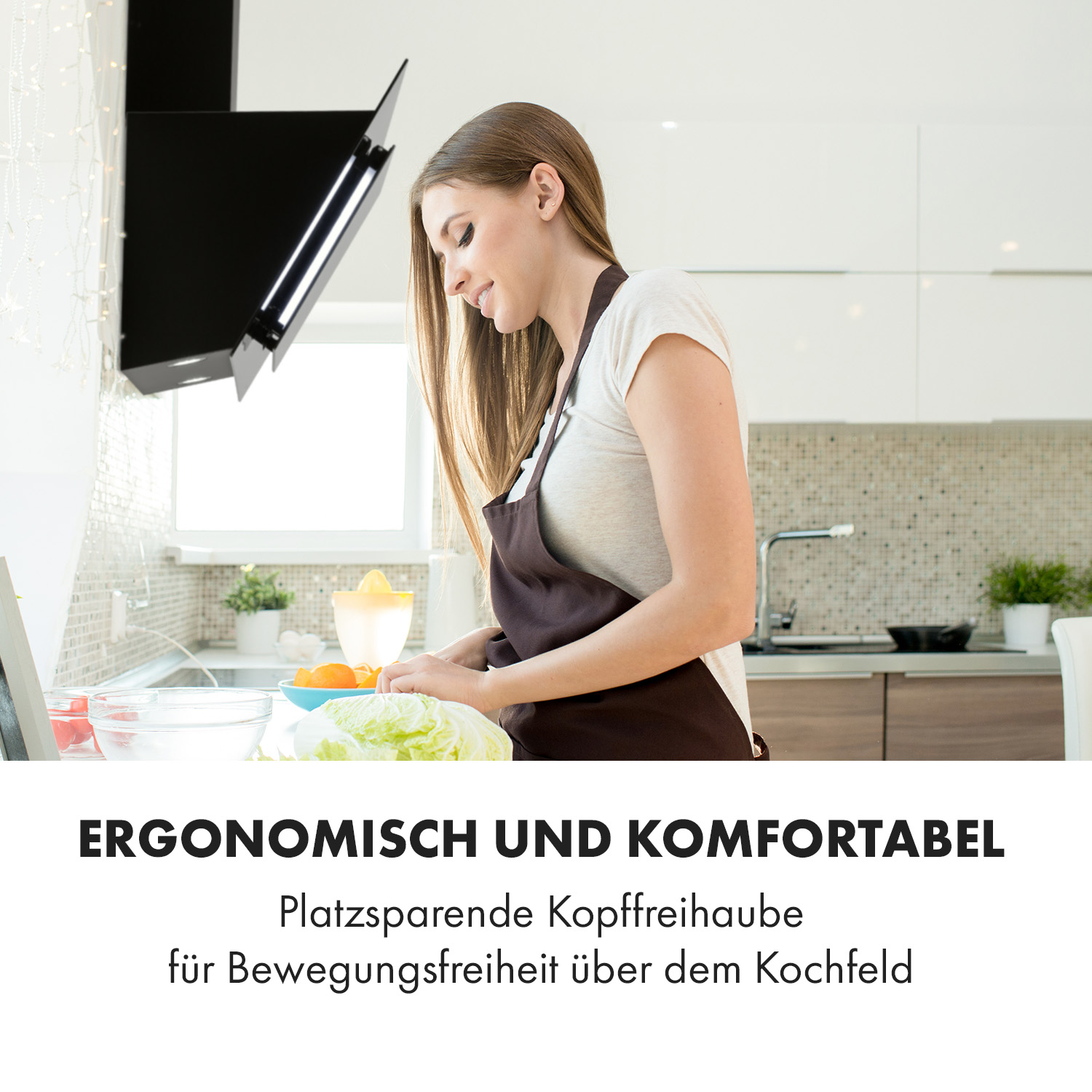 Donna con grembiule che prepara cibo in cucina. Cappa nera sopra di lei. Testo: ergonomico e confortevole.
