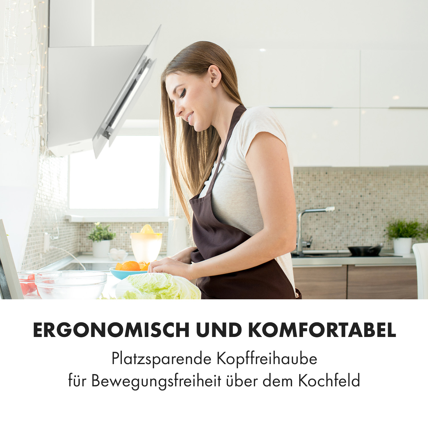 Una donna in cucina prepara cibo sotto una cappa bianca, promuovendo un design ergonomico e confortevole.