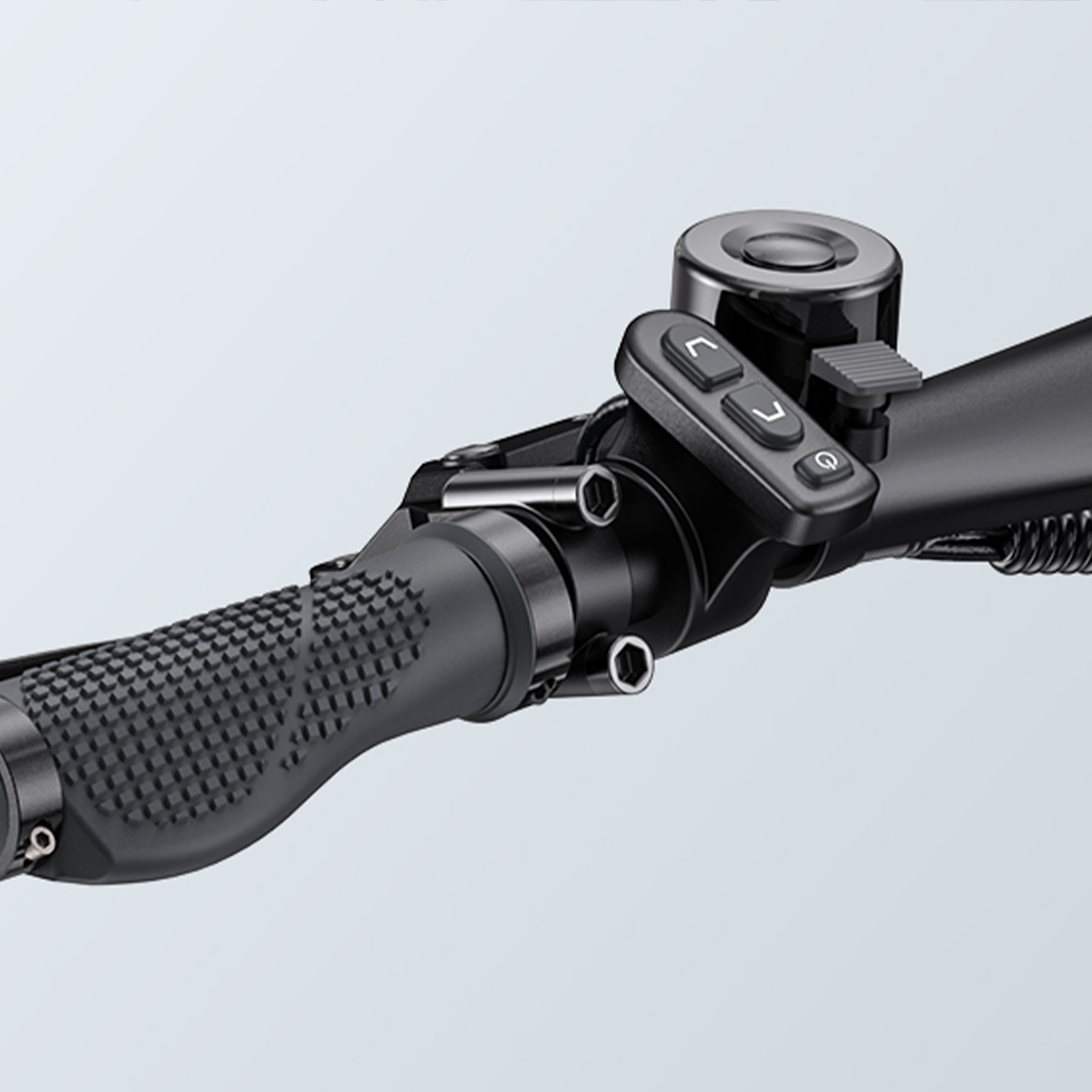 Zbliżenie kierownicy roweru. Ma teksturowany uchwyt, z przyciskami i światłem.