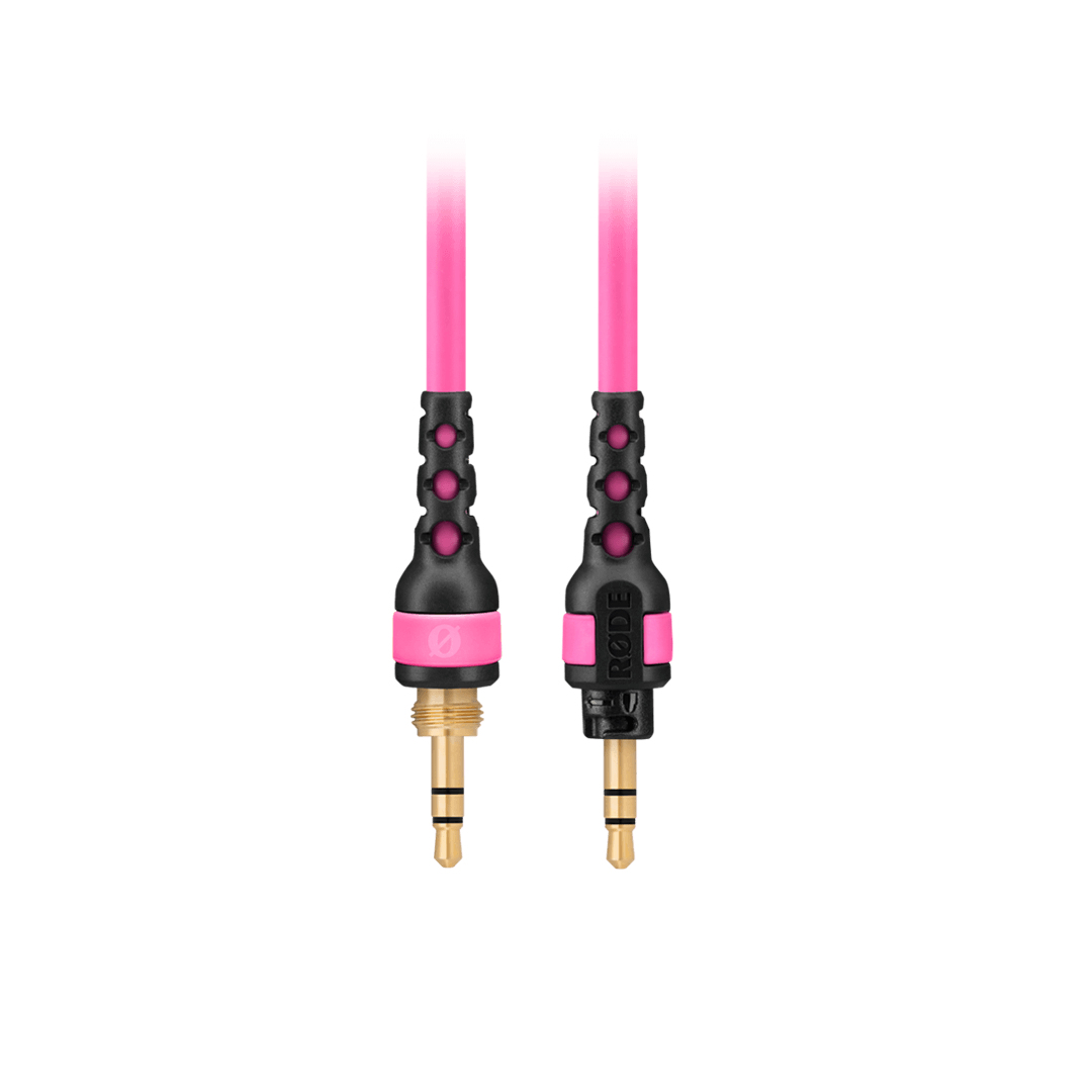 Zwei pinkfarbene Audiokabel mit schwarzen Steckern. Eines ist mit RØDE beschriftet.