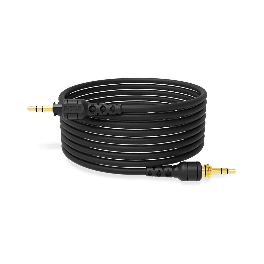 Cavo audio nero arrotolato, con connettori dorati, su una superficie bianca.