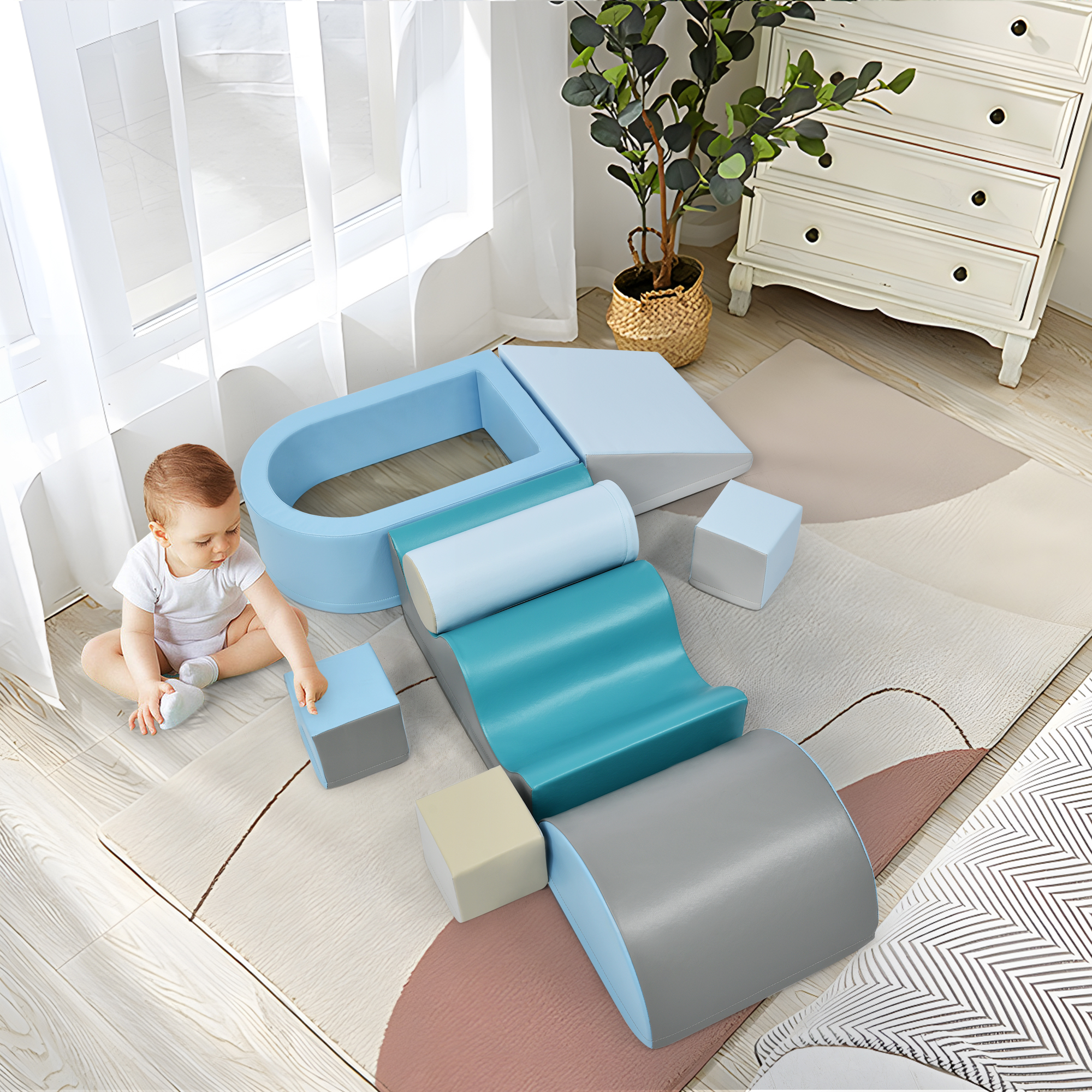 Baby spielt mit blauen und grauen Schaumstoffformen auf einem gemusterten Teppich, in der Nähe eines Fensters und einer weißen Kommode.