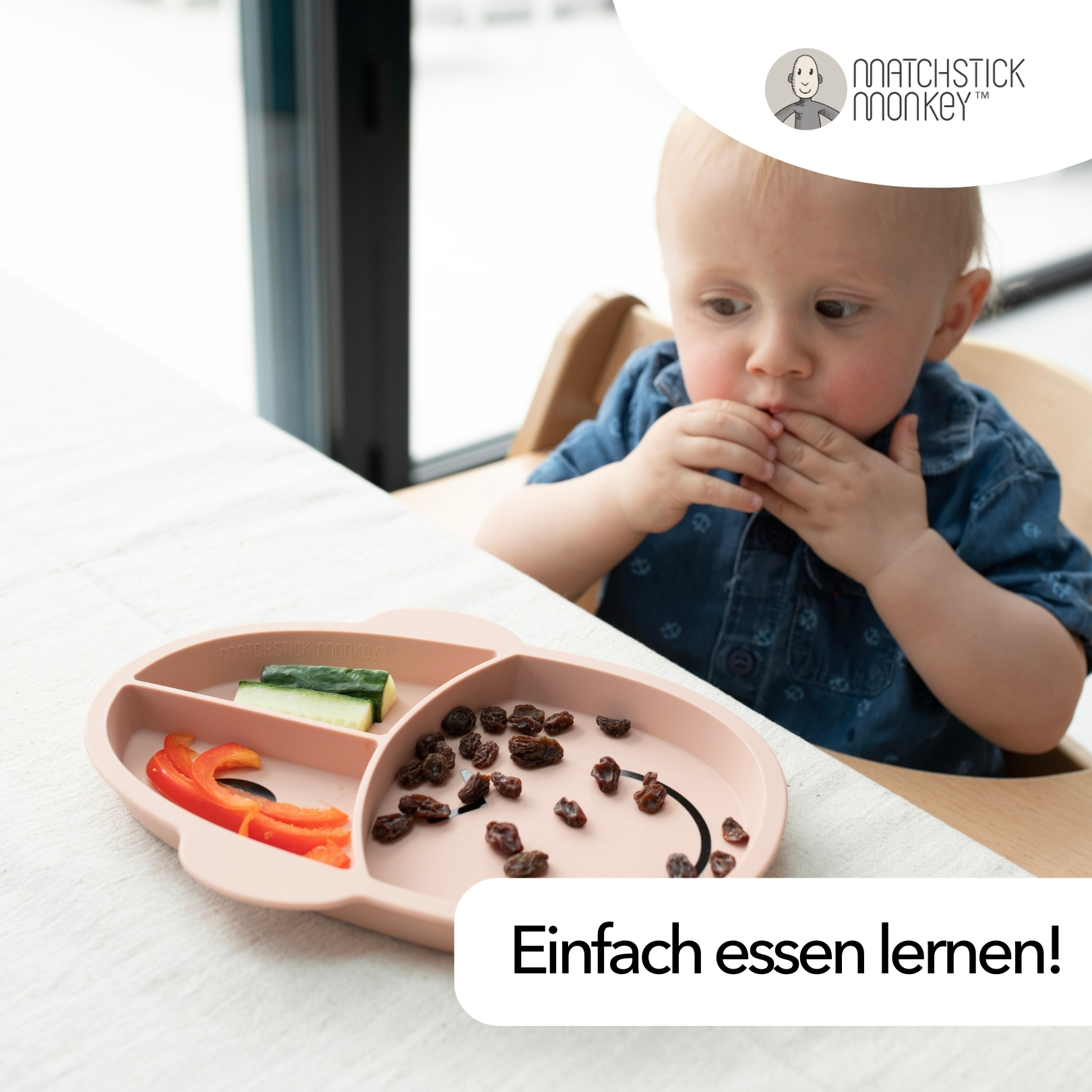 Baby isst von einem rosa Affenteller mit Essen, in einem Hochstuhl.