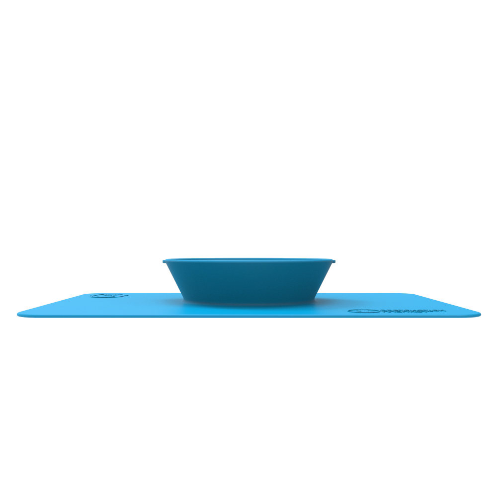 Blaue Schüssel auf einer blauen Platzmatte. Die Matte hat ein Logo. Weißer Hintergrund.