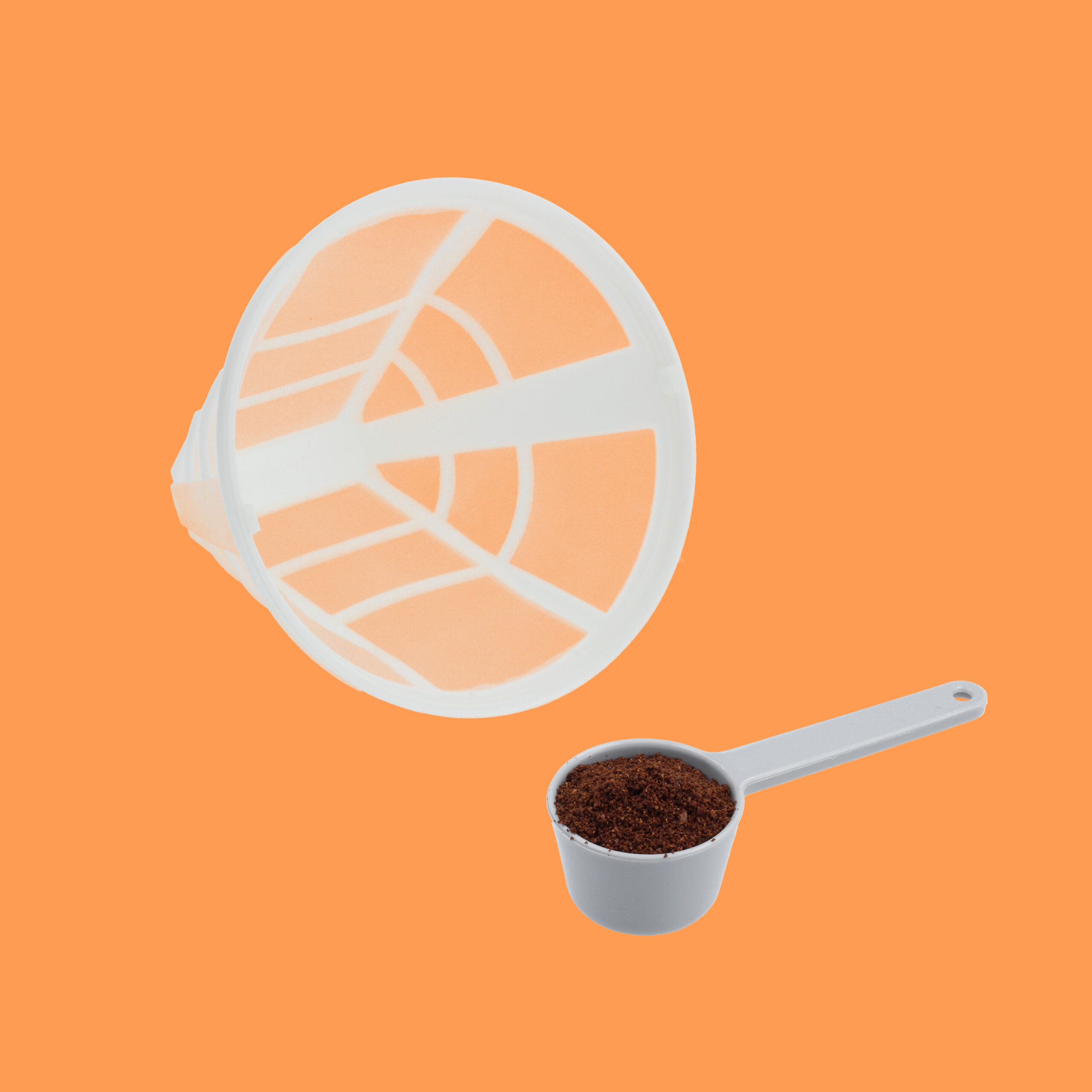 Filtr do kawy i miarka zmielonej kawy na pomarańczowym tle. Filtr jest biały, a miarka szara.