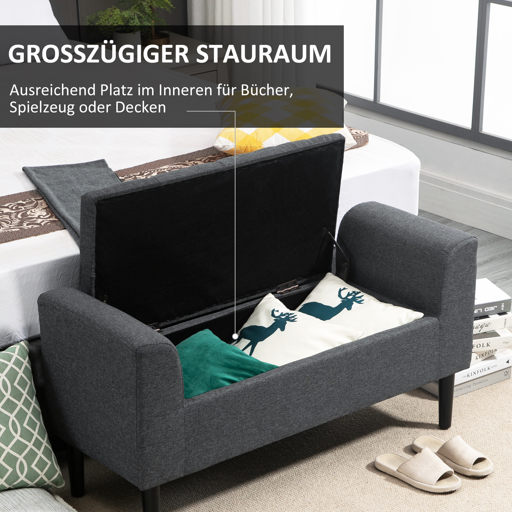 Eine graue Sitzbank geöffnet, die Stauraum zeigt. Kissen und Hausschuhe sind sichtbar.