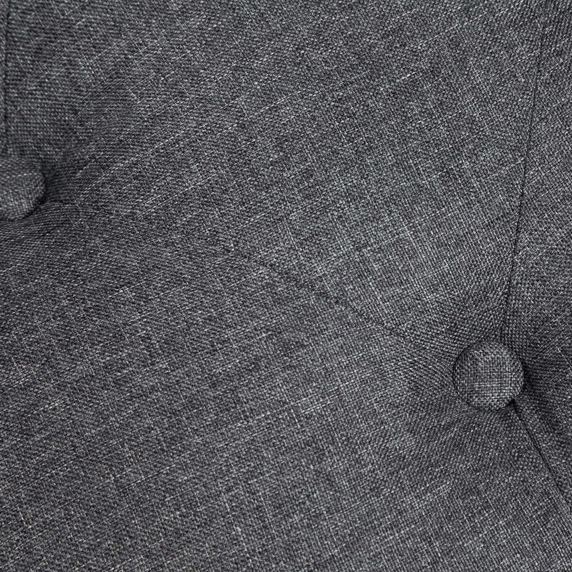 Nahaufnahme von grauem Stoff mit Knöpfen, zeigt Textur und subtile Muster.