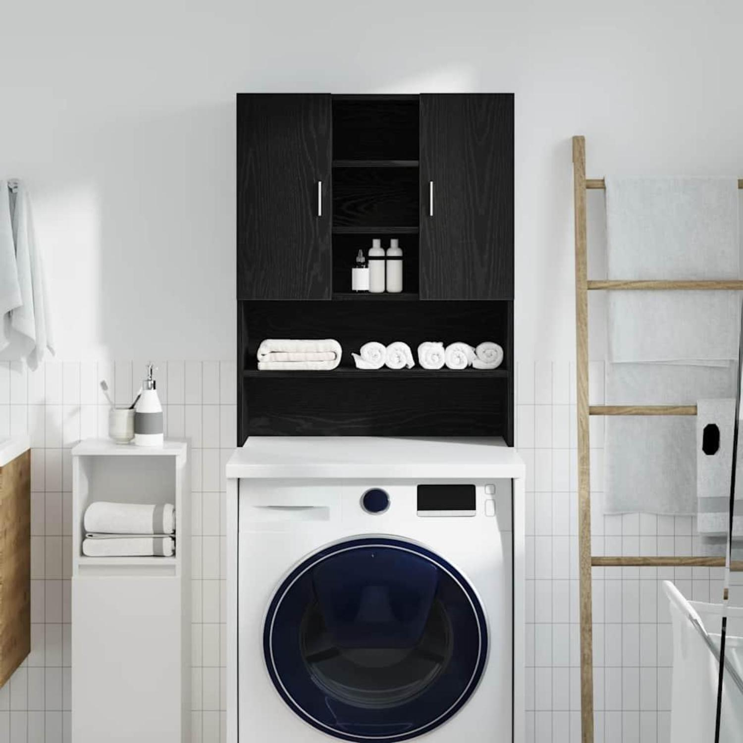 Weiße geflieste Wand mit schwarzem Schrank, Waschmaschine und Holzleiter mit Handtüchern.