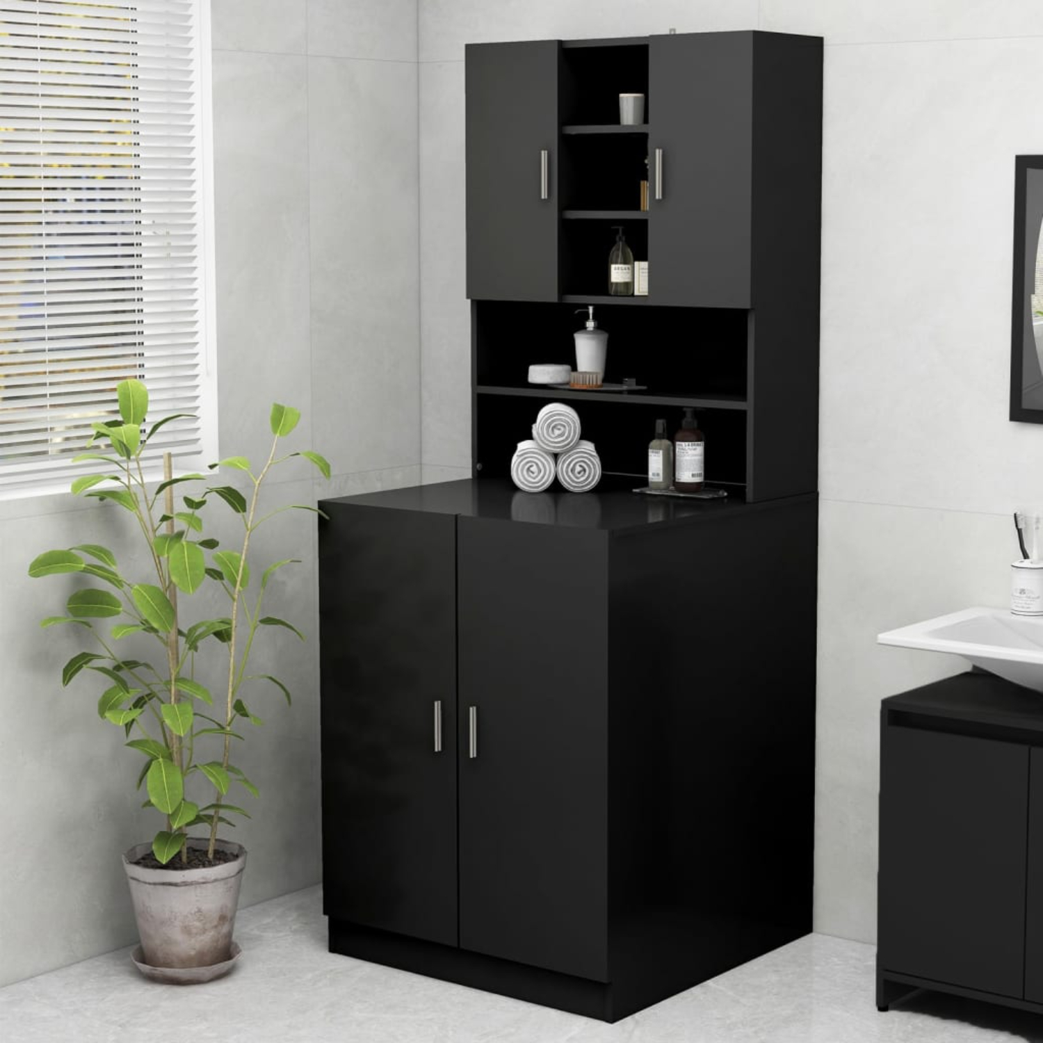 Schwarzer Schrank mit Regalen und geschlossenen Türen, mit Pflanze und Waschbecken im Hintergrund.