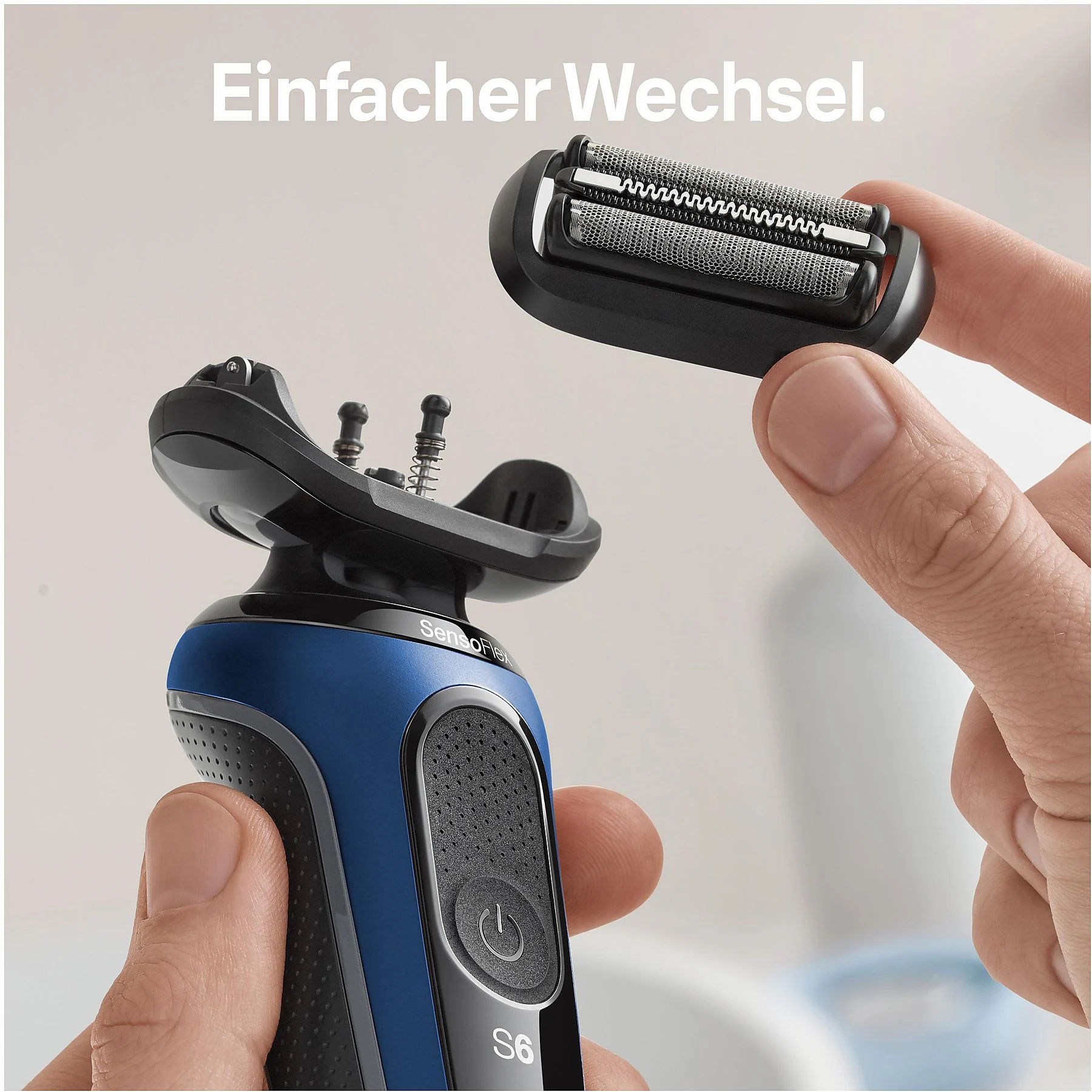 Eine Person hält einen Elektrorasiererkopf, dazu ein blau-schwarzer Rasierer.