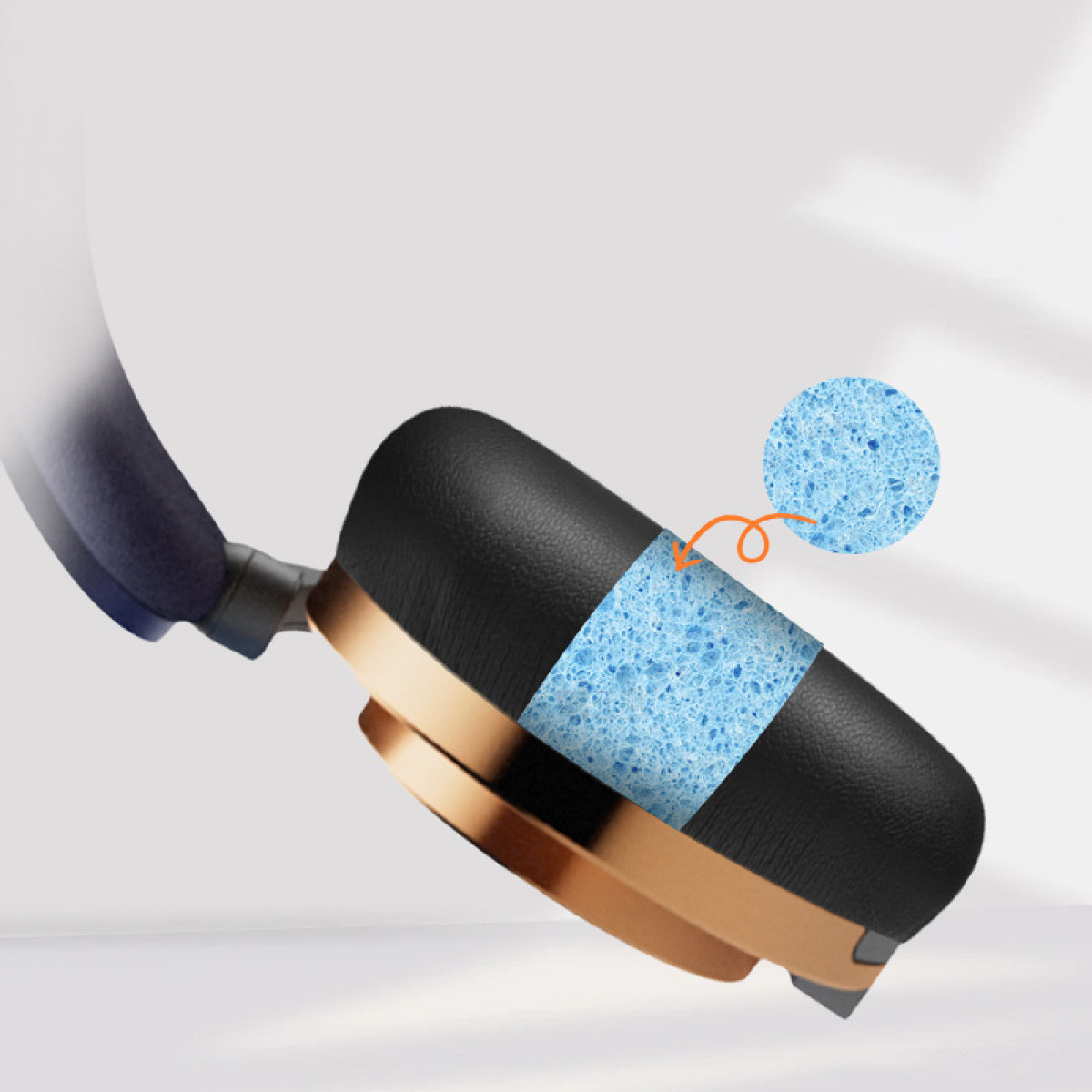 Hoofdtelefoon oorschelp met een blauwe sponslaag zichtbaar. Goud- en zwart kleurenschema.