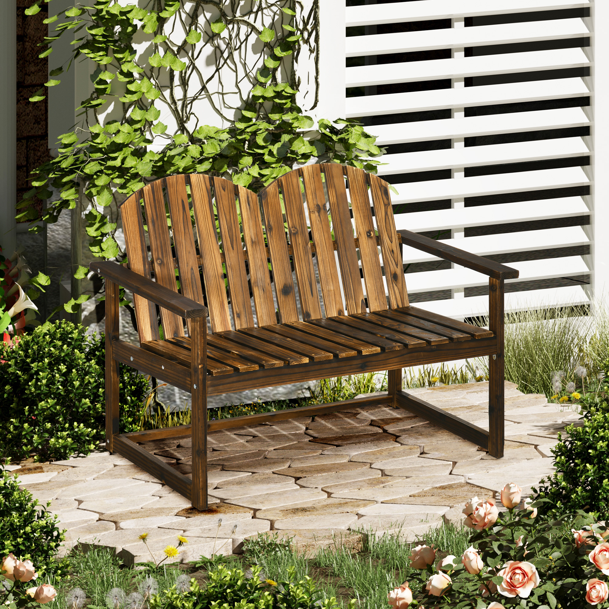 Eine Holzbank mit braunem Finish. Sie steht auf einer Backstein-Terrasse mit Blumen.