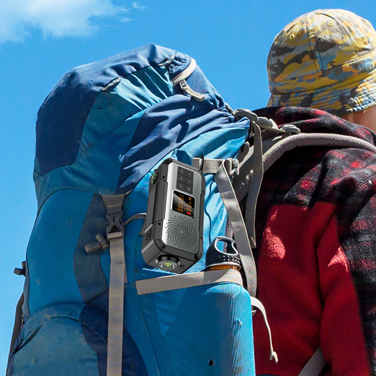 Ein Radio an einem blauen Rucksack befestigt. Eine Person mit Hut und Jacke im Hintergrund.