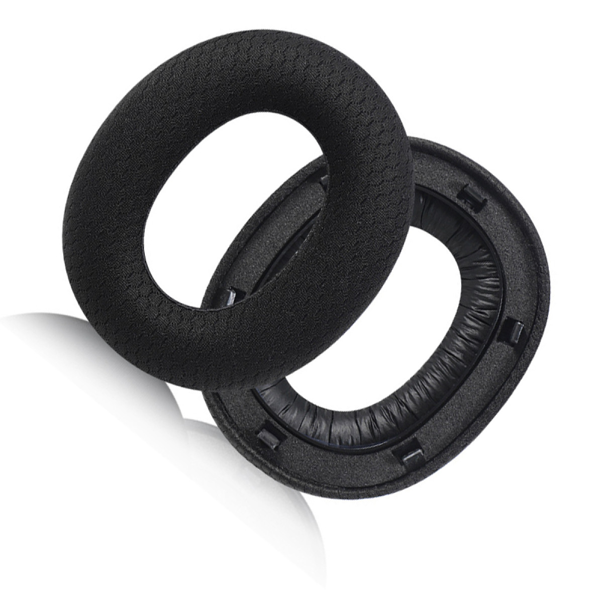 Due cuscinetti auricolari neri con tessuto nero su sfondo bianco.